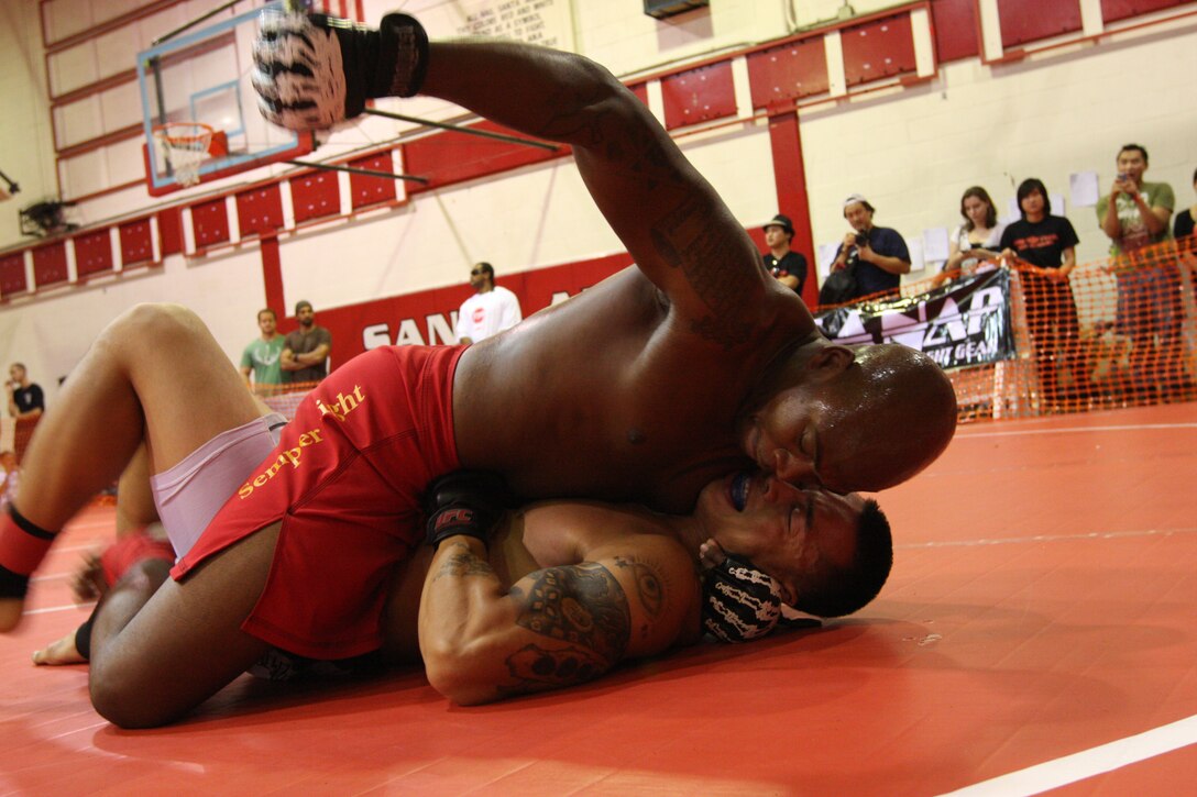 Middle heavyweight Fight Club 29 member Omar Askew (top) pounds his challenger’s ribs from the mount position during the U.S. National Pankration Championships in Santa Ana, Calif., Oct. 25. Askew won the match and continued on to claim the silver medal for his weight class. ::r::::n::