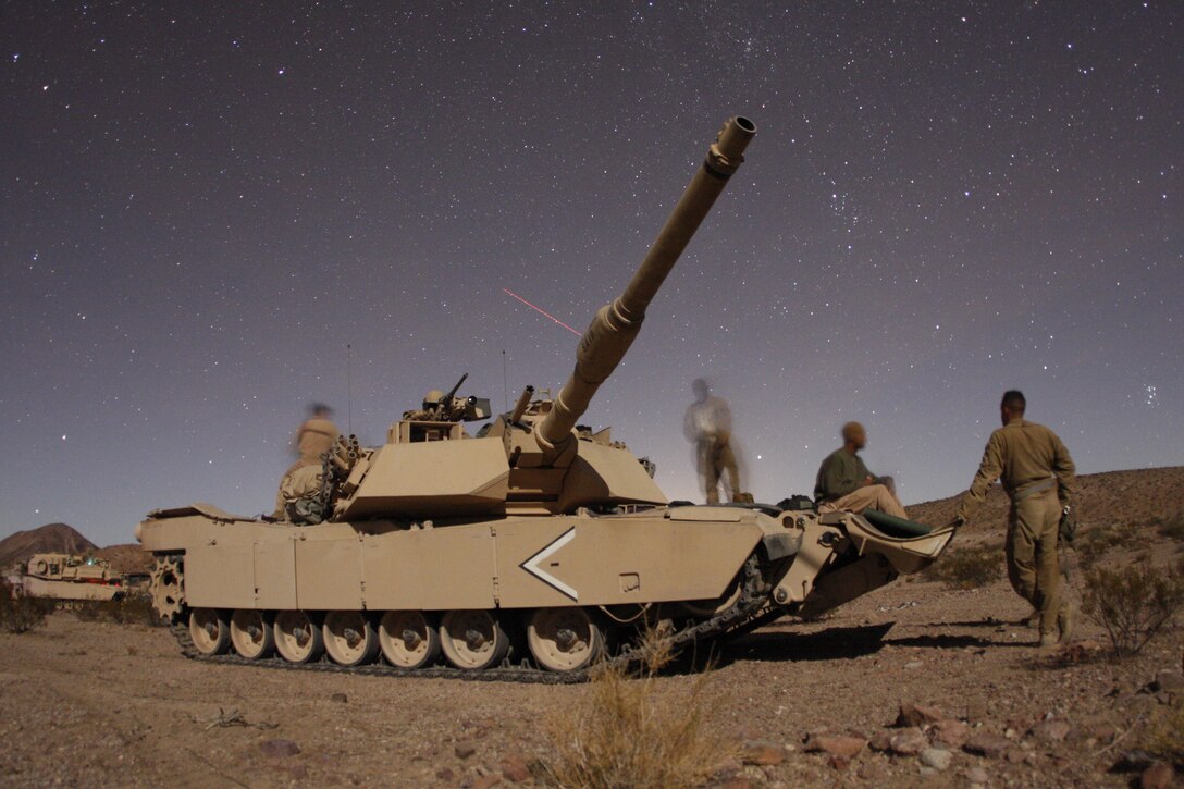 The crew of "That's What She Said," a tank with Company D, 1st Tank Battalion talks before going to bed Oct. 25, at the Combat Center during the combined arms exercise known as Steel Knight.