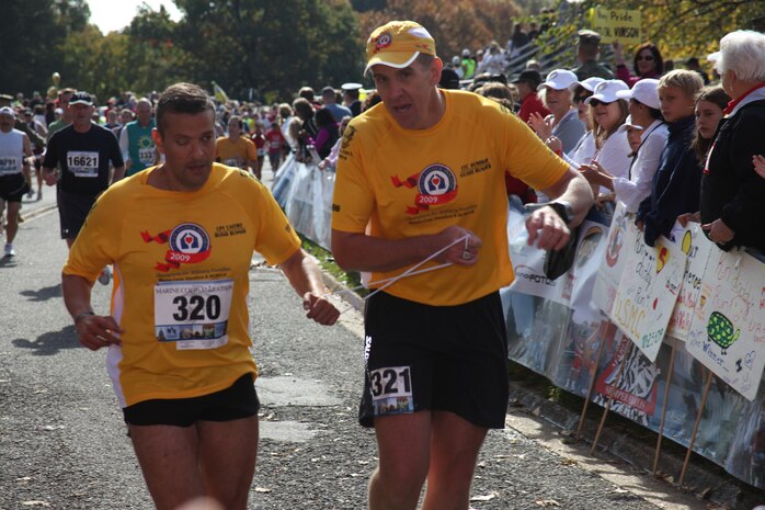A blind Ivan Castro, 41, is led through the finish line by Fred Dummar at the 34th Marine Corps Marathon Oct. 25, 2009. The 26.2 mile race took participants on a journey through the streets of Arlington, Va., and Washington, D.C. culminating with a finish at the Marine Corps War Memorial. Castro and Dummar finished the race in 4:03:57. ::r::::n::::r::::n::::r::::n::