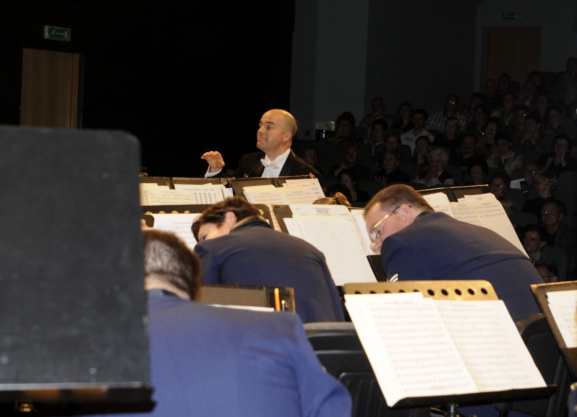 NOWY SACZ, Poland – Maj. Matt Henry, U.S. Air Forces in Europe Band’s commander and musical director, peers over the conductors podium during the Glenn Miller encore performance here at the Malopolskie Cenrum Kultury Sokol Oct. 22.  The band slowly crouches to the floor as the music gets softer only to jump back up as the music gets louder.  The 41-piece USAFE Concert Band is playing six concerts in six days, Oct. 20-25, to commemorate 90 years of Polish-American cooperation as part of Gen. Roger Brady’s, USAFE commander, international relations program in partnership with the U.S. State Department.  (U.S. Air Force photo/Master Sgt. Kelley J. Stewart)