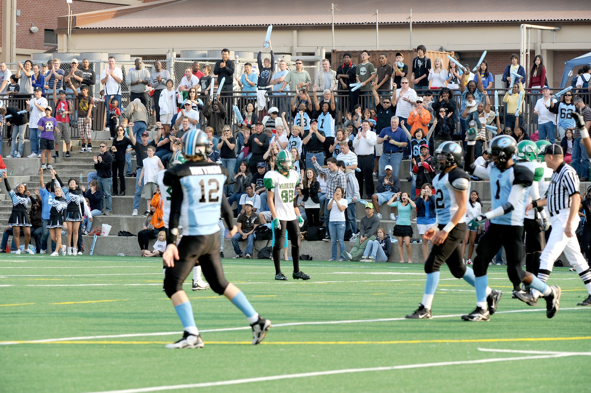 From left to right, Osan American High School players Jake Mattison (12), Carlos Rincon and Dominique Williams (1) celebrate after the final down of their game against Daegu American School Oct. 24 at Osan Air Base. OAHS held off a two-touchdown, fourth quarter rally from DAS to win their homecoming game 28-26. The teams will play again Oct. 30 at DAS for a chance to advance to the Far East Korea Small Schools playoff. (U.S. Air Force Photo by 1st Lt. Chris Hoyler)