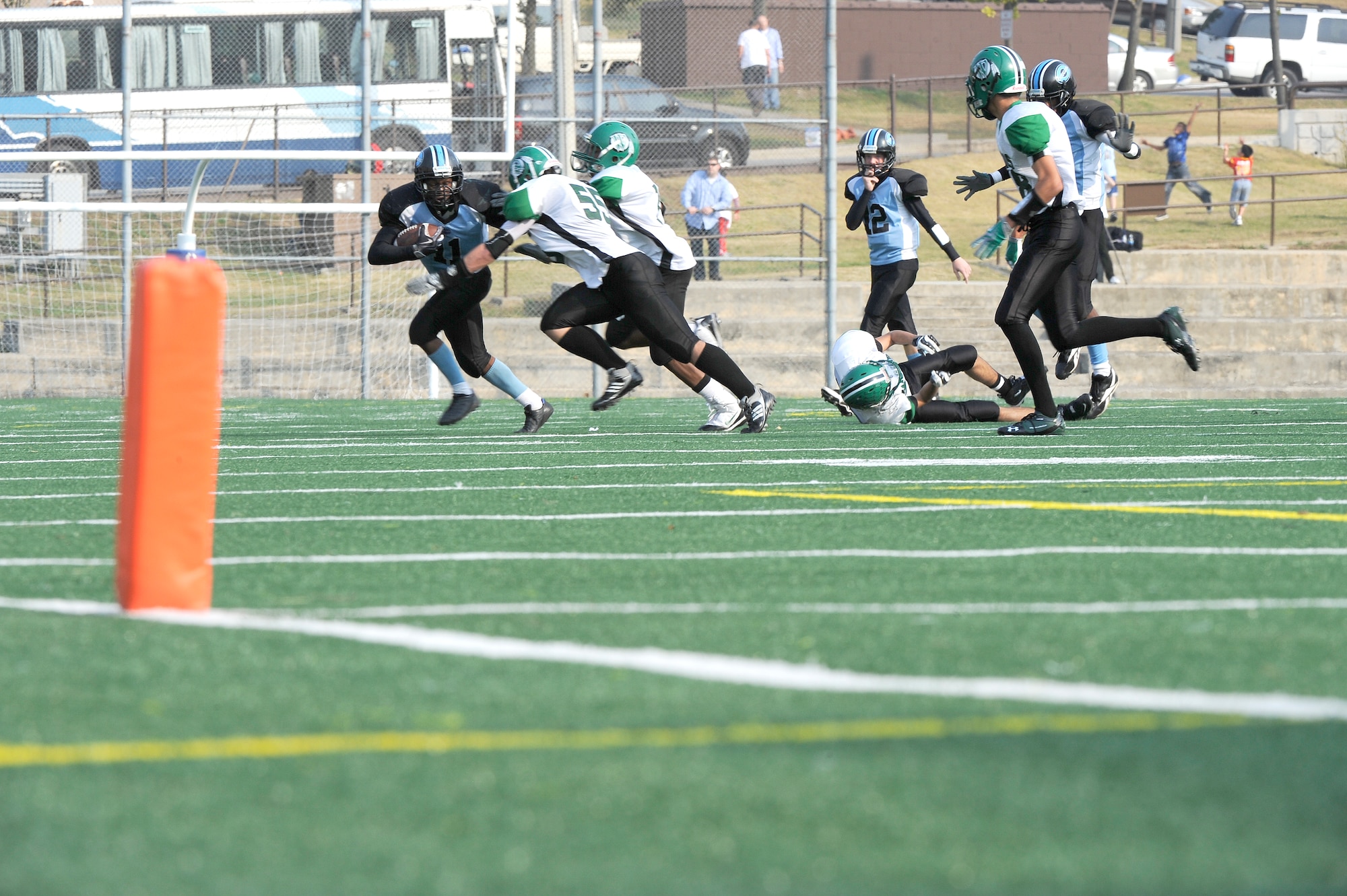 Osan American High School running back Julian Johnson, far left with ball, attempts to ward off tackles from Daegu American School players Anthony Lampman (55) and Darius Wyche during the teams' game at Osan Air Base Oct. 24. OAHS held off a two-touchdown, fourth quarter rally from DAS to win 28-26. The teams will play again Oct. 30 at DAS for a chance to advance to the Far East Korea Small Schools playoff. (U.S. Air Force Photo by 1st Lt. Chris Hoyler)