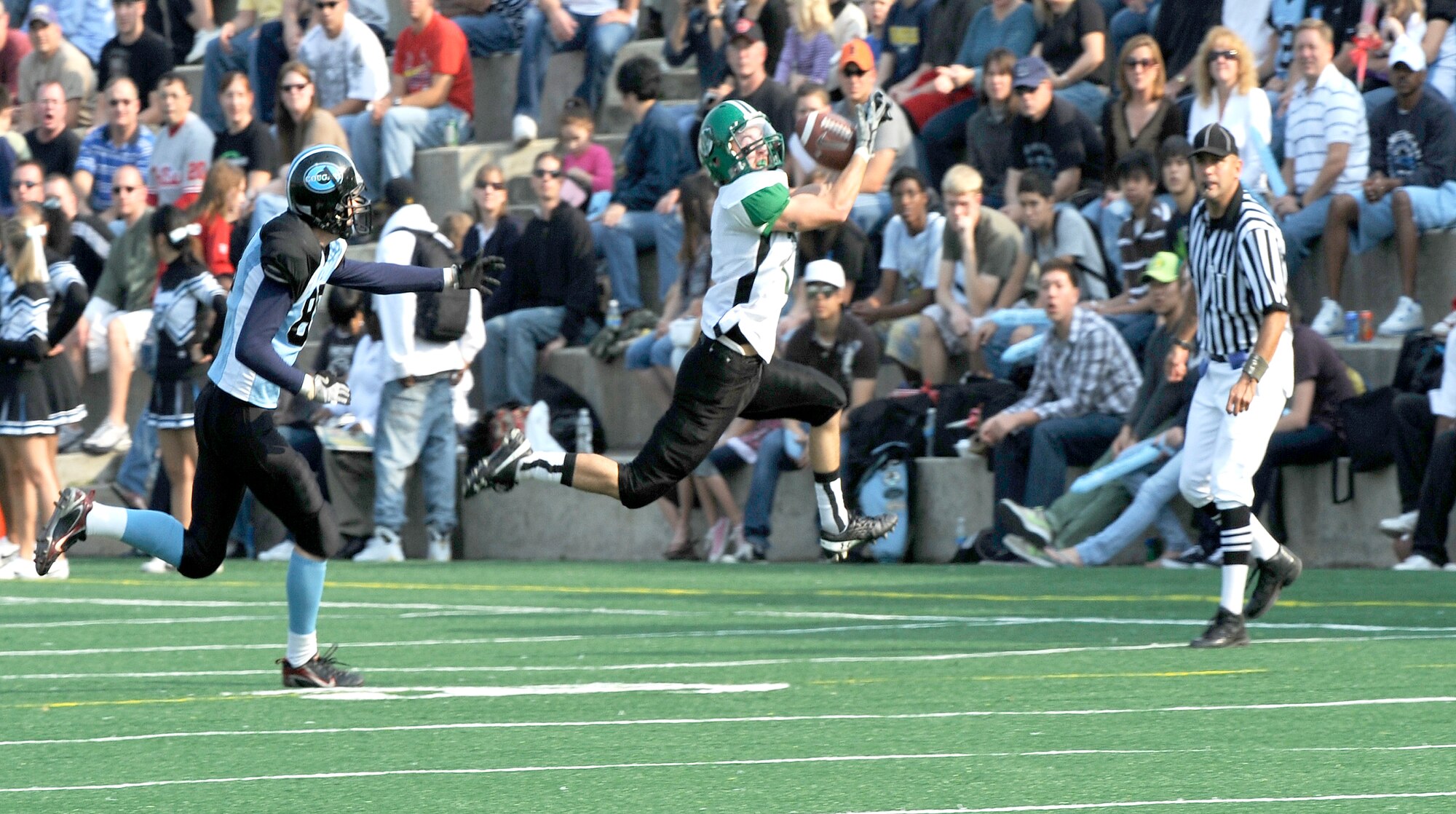 David Silva, right, a wide receiver for the Daegu American School Warriors, makes a leaping catch in front of Osan American High School linebacker Tim Neher during the teams' game at Osan Air Base Oct. 24. Osan held on despite a late comeback from Daegu to win 28-26. 