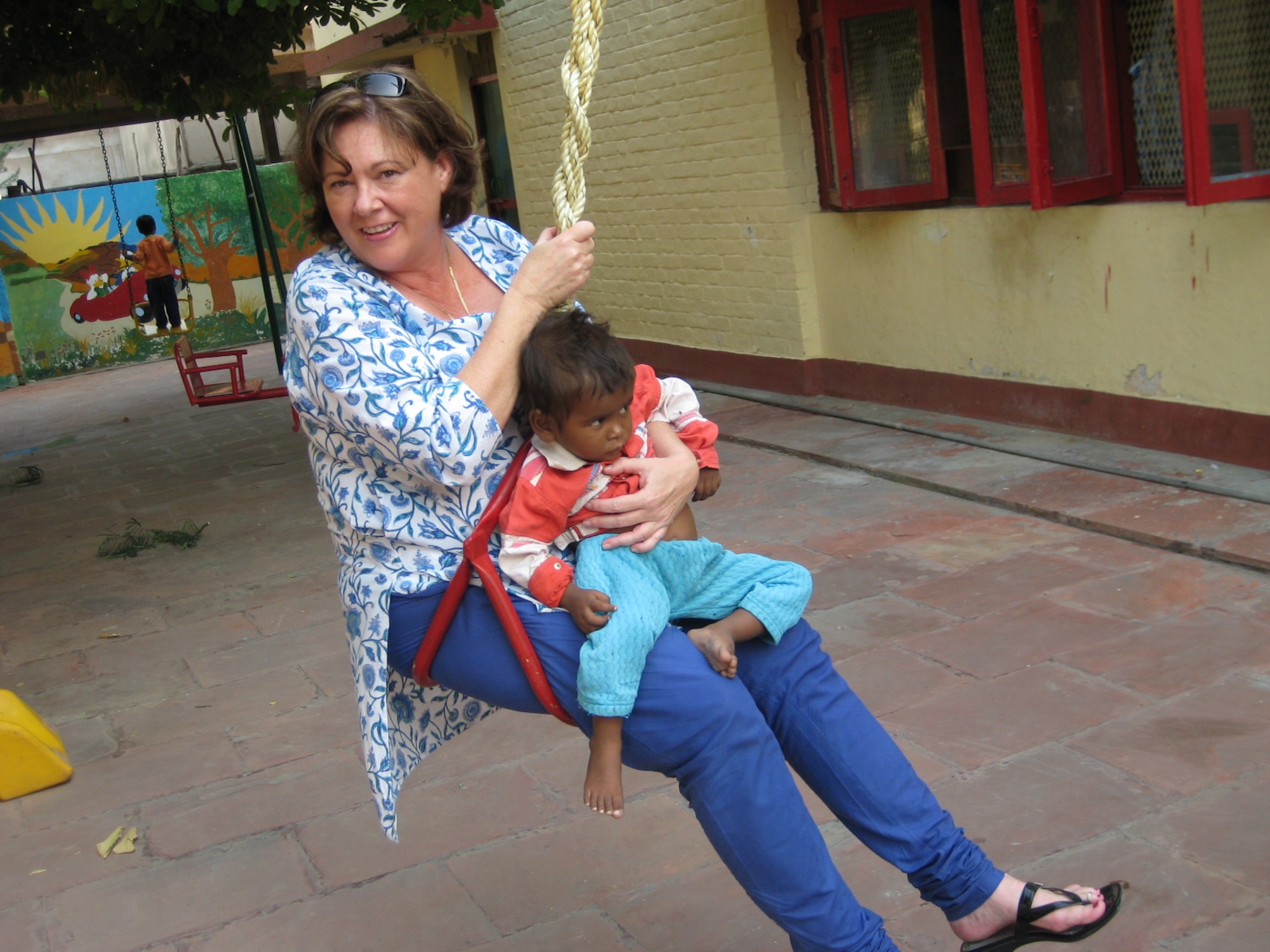 Maj. Lisa Nesselroad, International Affairs Advisor at 13th Air Force, Hickam Air Force Base, Hawaii, swings with an Indian boy during a visit to the Mother Teresa orphanage in Agra, India, Oct. 22. More than 150 Airmen and Soldiers volunteered their time with children and the elderly and donated cash, school supplies, food, and clothing during their visit. Cope India is a United States and India airlift exercise that provides training for humanitarian assistance and disaster relief operations. (U.S. Air Force photo/Capt. Genieve David)