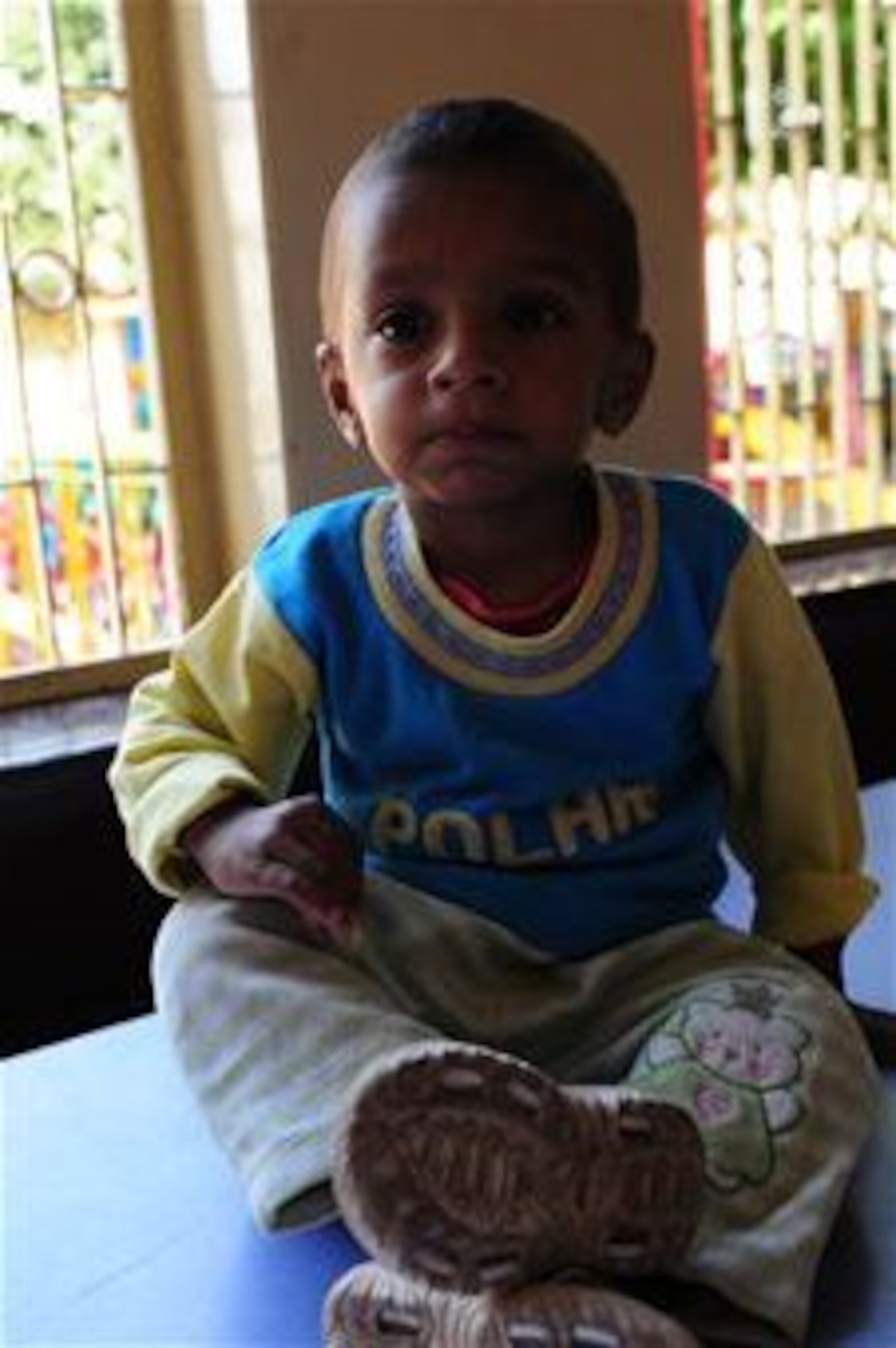 A Indian boy awaits the visit of more than 150 Airmen and Soldiers at the Mother Teresa orphanage in Agra, India, Oct. 22. The Airmen and Soldiers volunteered their time with children and the elderly and donated cash, school supplies, food, and clothing during their visit. Cope India is a United States and India airlift exercise that provides training for humanitarian assistance and disaster relief operations. (U.S. Air Force photo/Capt. Genieve David)