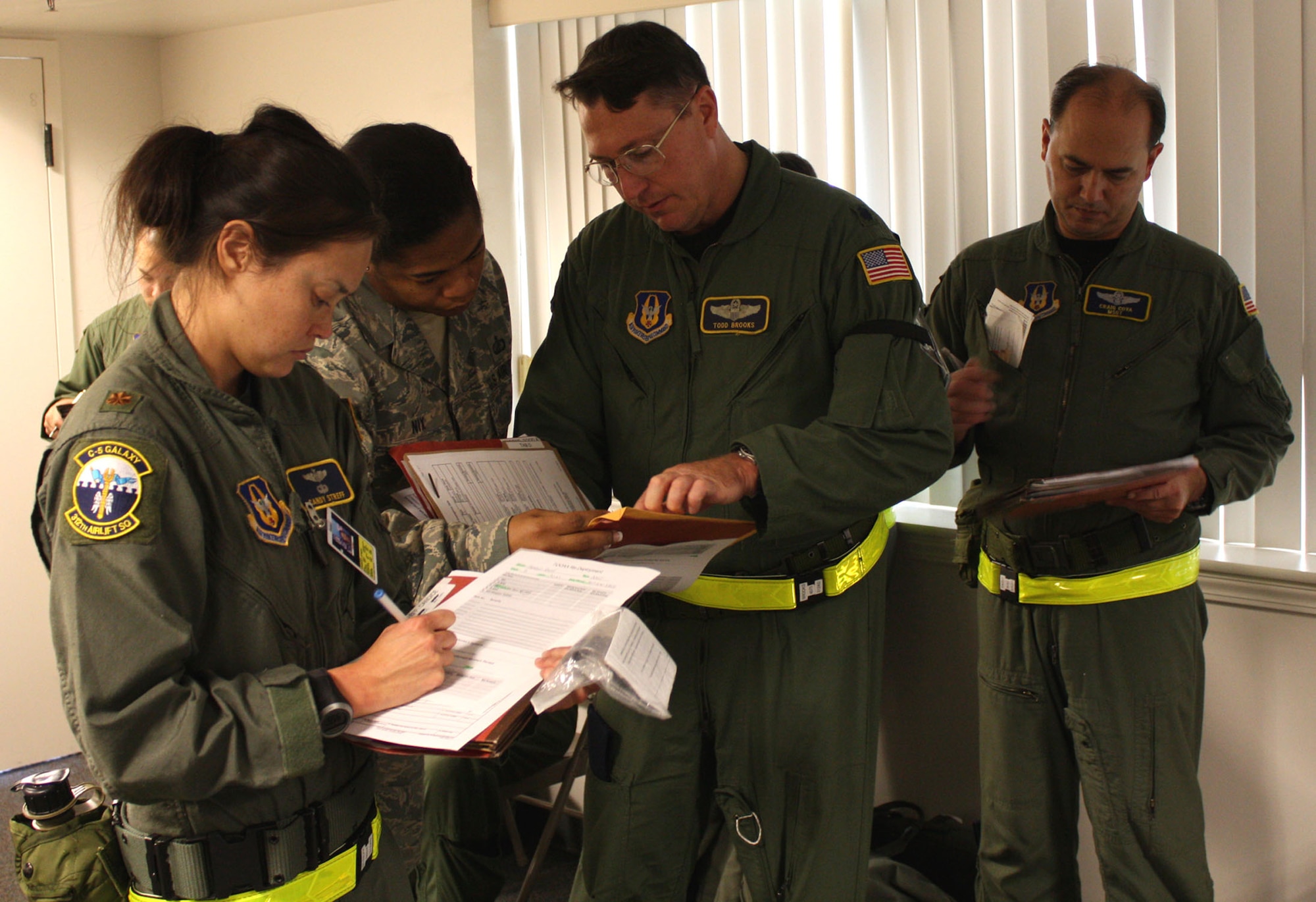 TRAVIS AIR FORCE BASE, Calif. -- 312th Airlift Squadron members receive travel voucher assistance from FM comptroller Tech. Sgt. Carmelita Nix during the redeployment process, Oct. 24. They performed their missions under wartime conditions during the Operational Readiness Inspection. (U.S. Air Force photo/Master Sgt. Robert Wade)

