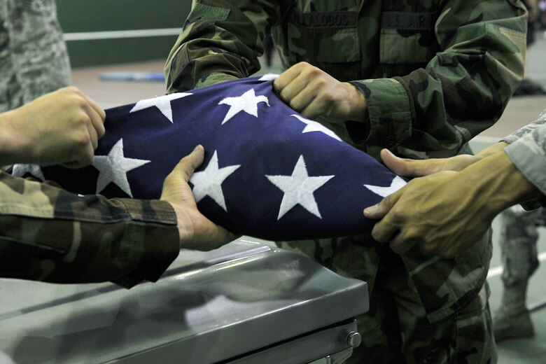 OFFUTT AIR FORCE BASE, Neb., -- Members of Offutt's Honor Guard, along with honor guard members from numerous installations fold an American Flag during an Air Force Honor Guard training session at the Martin Bomber Building here Oct. 21. The Air Force Honor Guard visited Offutt to evaluate and help sharpen the skills of Offutt's Honor Guard members, as well as honor guard members from numerous installations. U.S. Air Force Photo by Charles Haymond