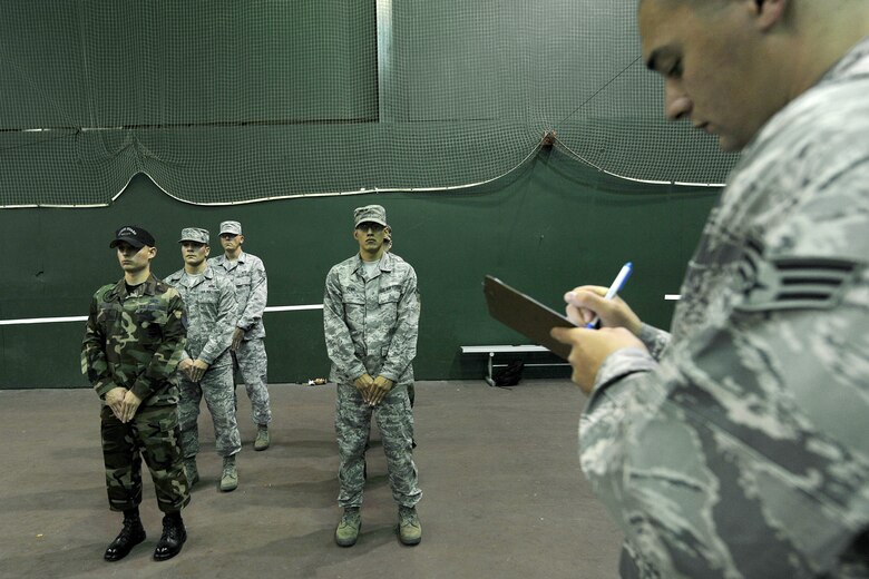 OFFUTT AIR FORCE BASE, Neb., -- Senior Airman Noel Sweeney, Air Force Honor Guard, evaluates members of Offutt's Honor Guard, as well as honor guard members from surrounding bases, on their ability to stand at parade rest for an extended period of time during a training session at the Martin Bomber Building here Oct. 21.  The Air Force Honor Guard visited Offutt to evaluate and help sharpen the skills of honor guard members from a number of installations. U.S. Air Force Photo by Charles Haymond