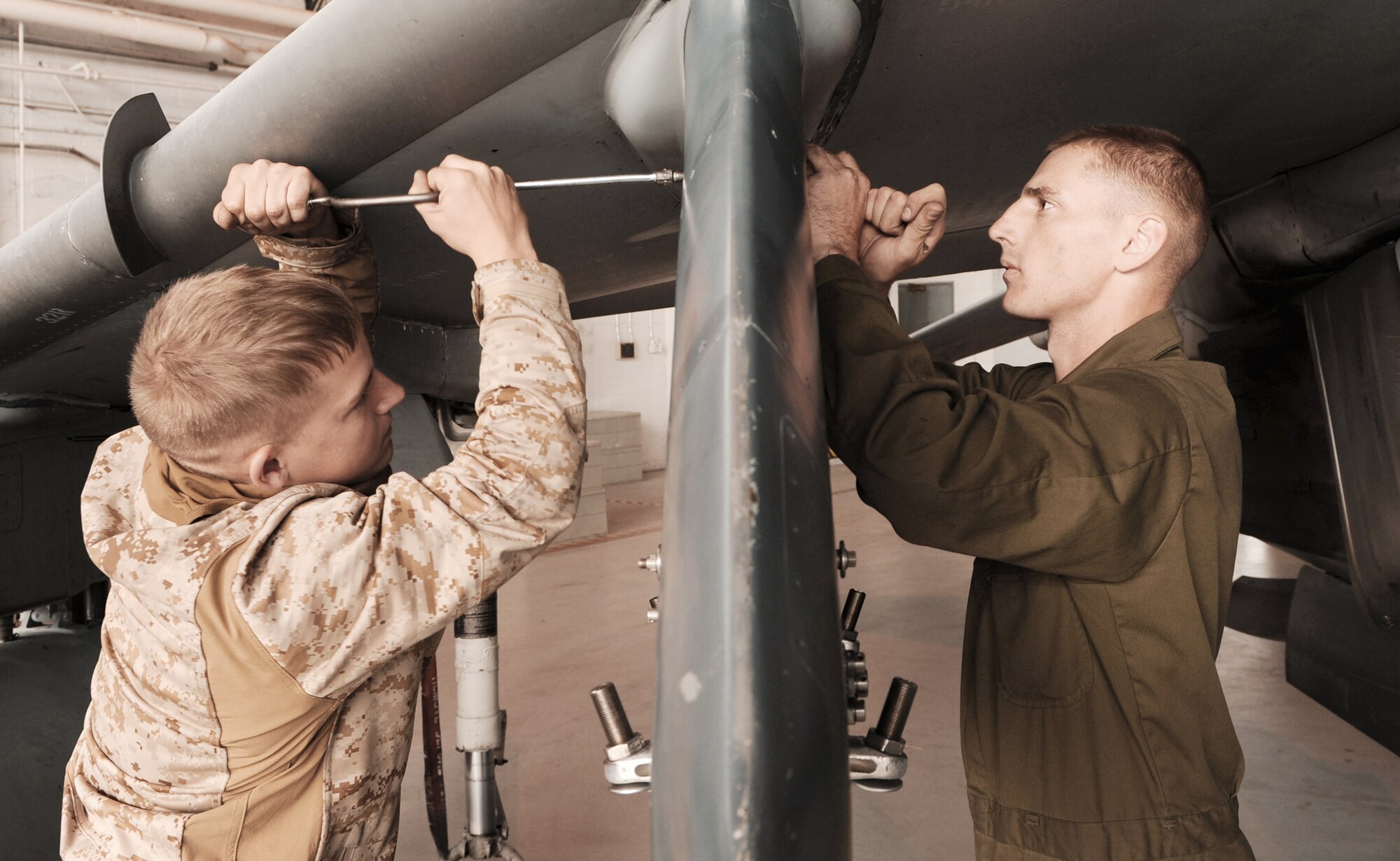 Cpl. Jason Fowler (left) and Lance Cpl. Wayne Aman, both Marine Attack Squadron 542 ordnance technicians from Cherry Point, N.C., fix a fuel leak on an AV-8B Harrier II Oct. 21, 2009, during the Mountain Roundup exercise at Mountain Home Air Force Base, Idaho. Mountain Roundup is a large-force exercise running Oct. 15 through Oct. 30 and includes participants from the German air force, U.S. Air Force, U.S. Navy and U.S. Marines. (U.S. Air Force photo/Airman 1st Class Debbie Lockhart)
