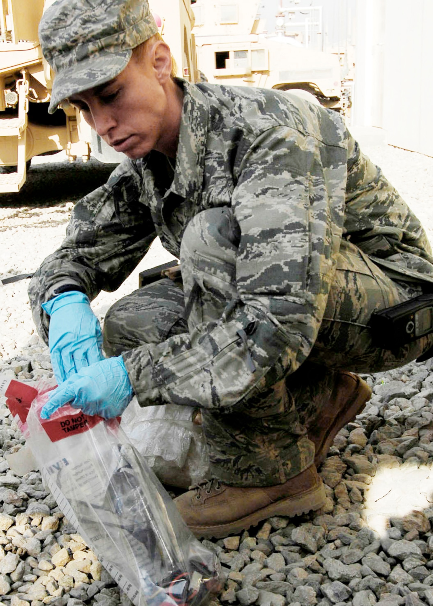 Staff Sgt. Elizabeth Spradley, an explosive ordnance disposal technician at Bagram Airfield, Afghanistan, collects evidence from a mock improvised explosive device during training Oct. 26, 2009.  EOD teams use robots during missions to disarm IEDs and look for additional IEDs while ensuring coalition maximum safety when dealing with IEDs. Sergeant Spradley is a joint expeditionary tasked Airman attached to the 741st EOD Battalion. She is an Albuquerque, N.M., native deployed from Spangdahlem Air Base, Germany. (U.S. Air Force photo/Senior Airman Felicia Juenke) 