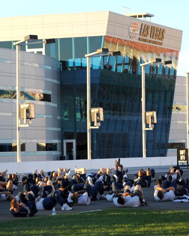 LAS VEGAS -- Members of the 99th Civil Engineering Squadron perform calisthenics at the Las Vegas Motor Speedway, prior to performing a 1.5 mile run, Oct. 26. (U.S. Air Force photo by Airman 1st Class Stephanie Rubi) 