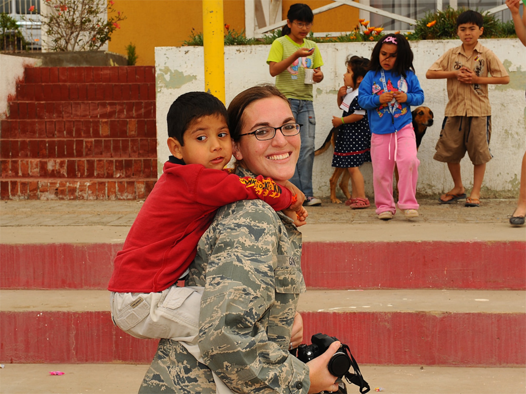 Capt Nicole Golden, 355th Fighter Wing Chief of Intel Operations, gives a piggyback ride to a child at the Aldeas SOS orphanage in Antofagasta, Chile on Sunday.  Capt Golden was one of more than 40 Airmen from the US, Chilean and Argentine Air Forces who visited the home while taking time off from exercise SALITRE, a five-nation exercise focused on peacekeeping operations.   (U.S. Air Force photo by Master Sgt. Daniel Farrell)