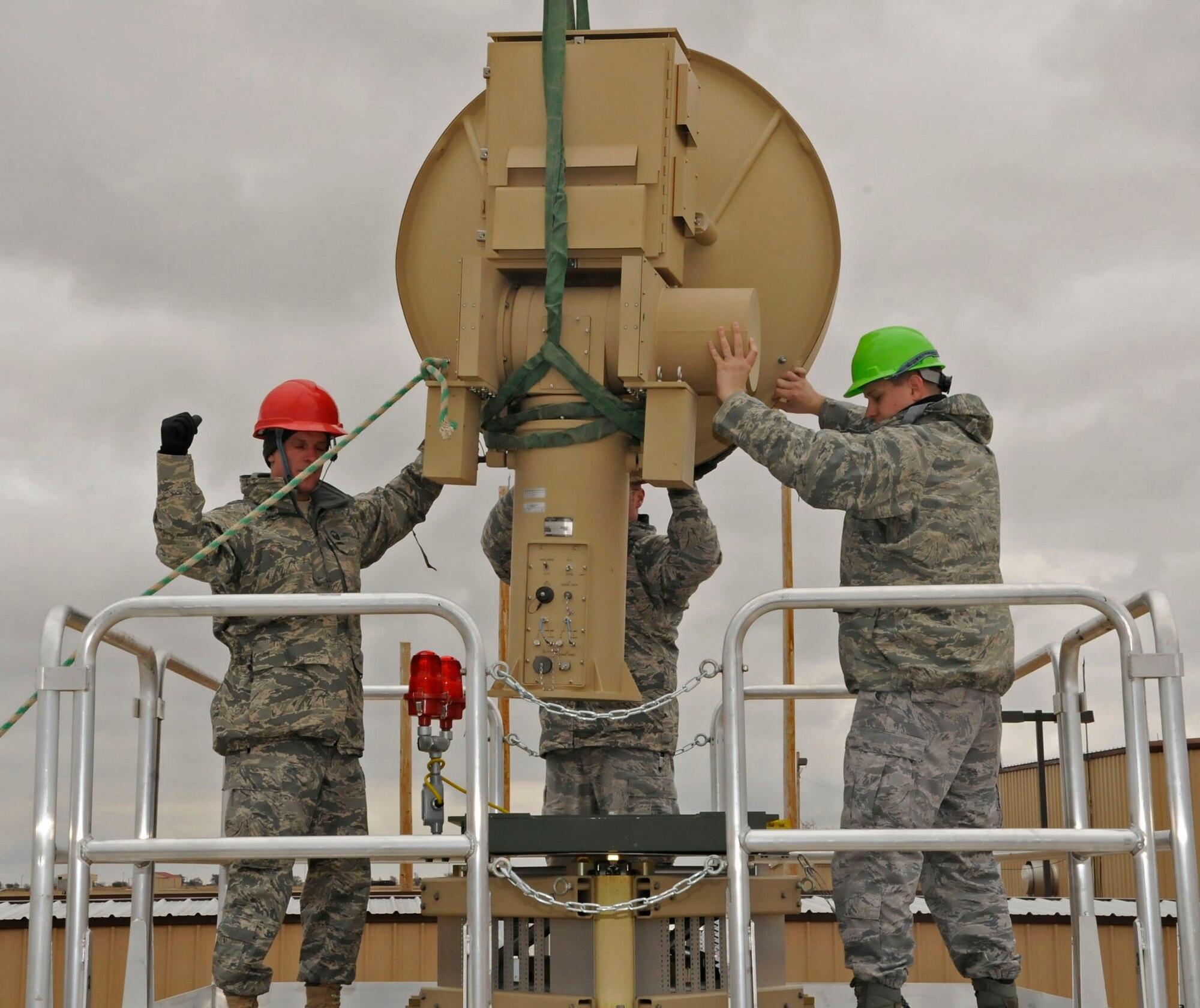 CANNON AIR FORCE BASE, N.M. -- Members of the 27th Special Operations Aircraft Maintenance Squadron, help guide a ground data terminal antenna on a trailer here, Oct. 26. 27 SOAMXS maintainers support flightline operations 24 hours a day, 7 days a week and are essential to the mission. (U.S. Air Force photo/ Senior Airman Erik Cardenas)