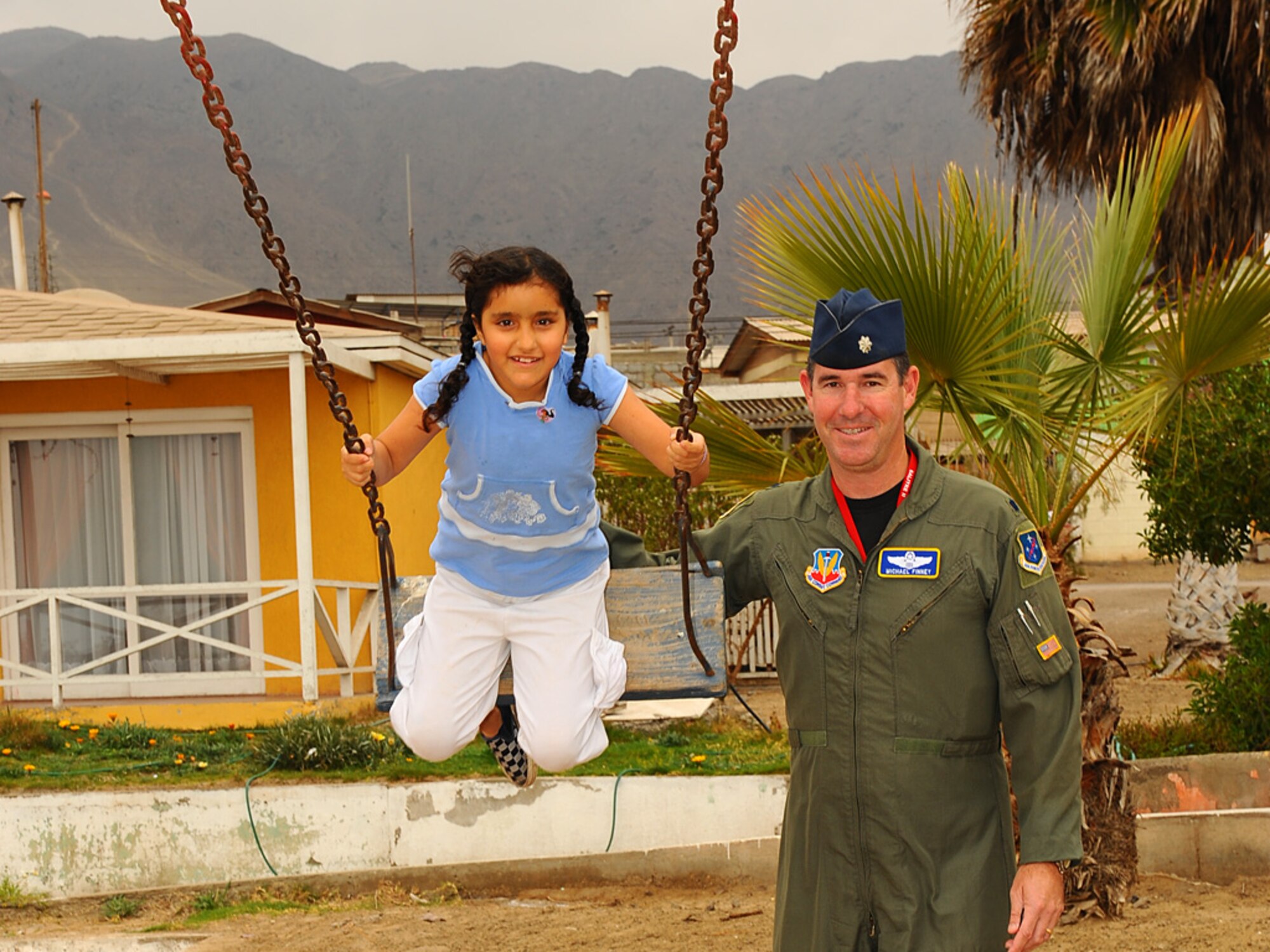 Lt Col Michael Finney, the 612th Air Operations Center Deputy Director of Combat Operations, pauses for a a photograph as he pushes a young Chilean girl on a swing at the Aldeas SOS orphanage.  The home, located in Antofagasta, Chile hosted more than 40 Airmen from 12th Air Force (Air Forces Southern), the 159th Fighter Wing, and members of the Chilean and Argentine Air Forces, for an afternoon of fun and festivies.  Airmen distributed candy and donated items to the home for orphaned and abandoned children on Sunday as they took a break from exercise SALITRE to reach out to members of the local community during the combined visit.  (U.S. Air Force photo by Master Sgt. Daniel Farrell)