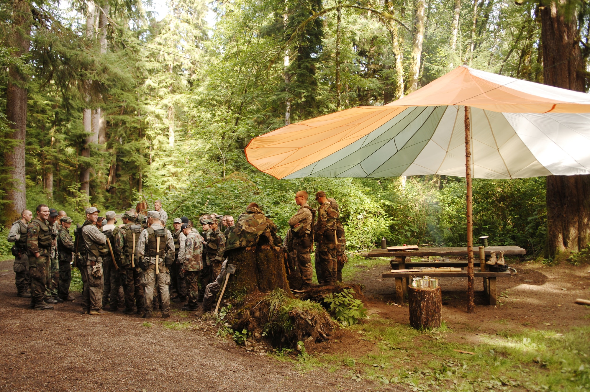 Students in the Survival, Evasion, Resistance and Escape Course from Fairchild Air Force Base, Wash., gather for instruction next to their fire circle Sept. 16, 2009 in the Hoh Rainforest in the Olympic National Forest in Washington. (U.S. Air Force photo/Senior Airman Emerald Ralston) 