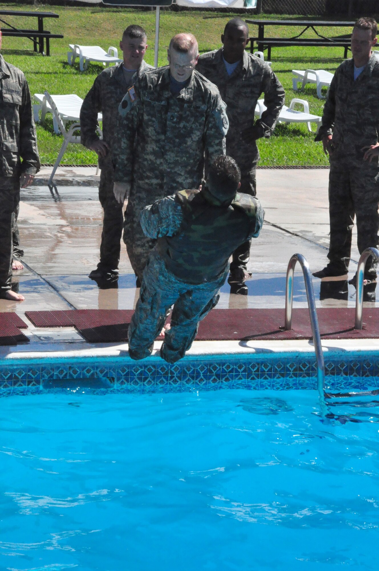 Army Sergeant First Class Michael Glancey sends Air Force Staff Sgt. Brian Peters into the water to practice removing personal equipment quickly during Water Survival Training at the Soto Cano Air Base swimming pool Thursday, Oct. 22, 2009. Sergeant Glancey instructed Sergeant Peters and 13 other personnel recovery team members on a variety of water-based tactics to prepare them to operate safely in rescue and recovery missions. (U.S. Air Force photo/Tech. Sgt. Mike Hammond)
