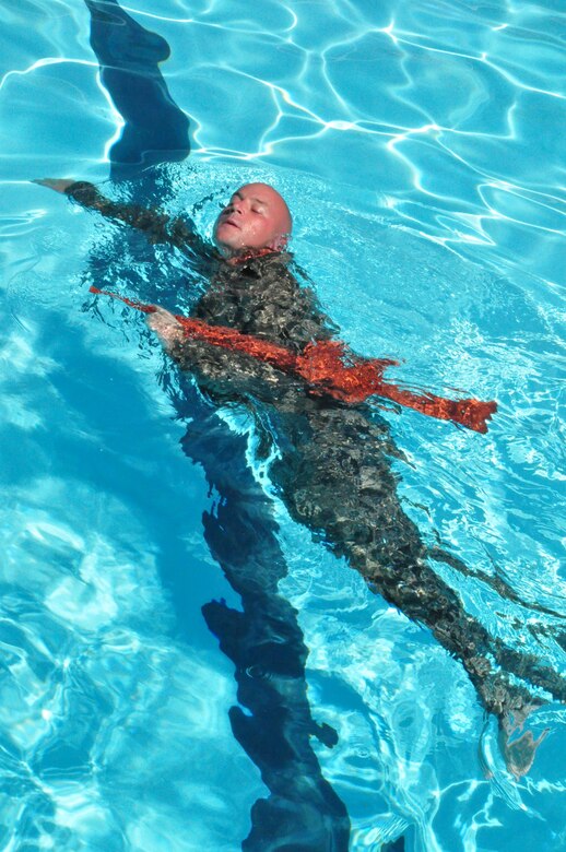 Air Force Senior Airman Benjamin Lowers trains on retrieving and swimming with a weapon during Water Survival Training at the Soto Cano Air Base swimming pool Thursday, Oct. 22, 2009. Airman Lowers was one of 14 personnel recovery team members receiving training on a variety of water-based tactics to prepare them to operate safely in rescue and recovery missions. (U.S. Air Force photo/Tech. Sgt. Mike Hammond)