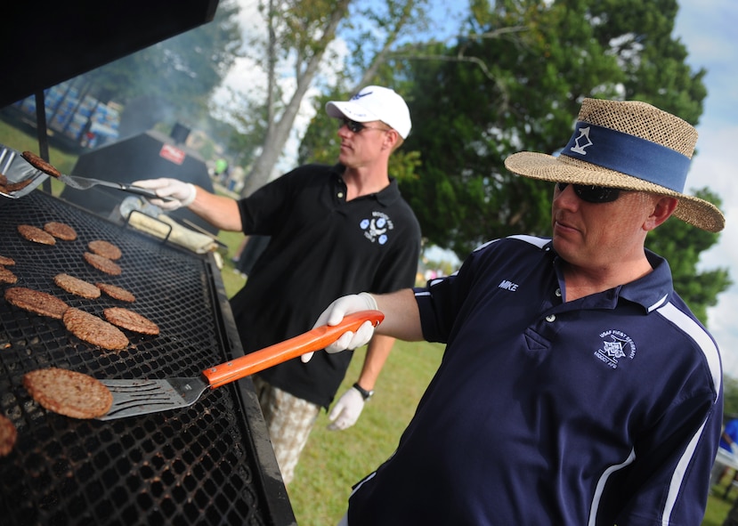 MOODY AIR FORCE BASE, Ga. -- Senior Master Sgt. Michael Claiborn, 723rd Aircraft Maintenance Squadron first sergeant, and Master Sgt. Tracy Tackling, 23rd Civil Engineer Squadron unit deployment manager, flip hamburgers and hotdogs during the 23rd Wing Super Sports Day here Oct. 23.  (U.S. Air Force photo by Senior Airman Gina Chiaverotti-Paige)
