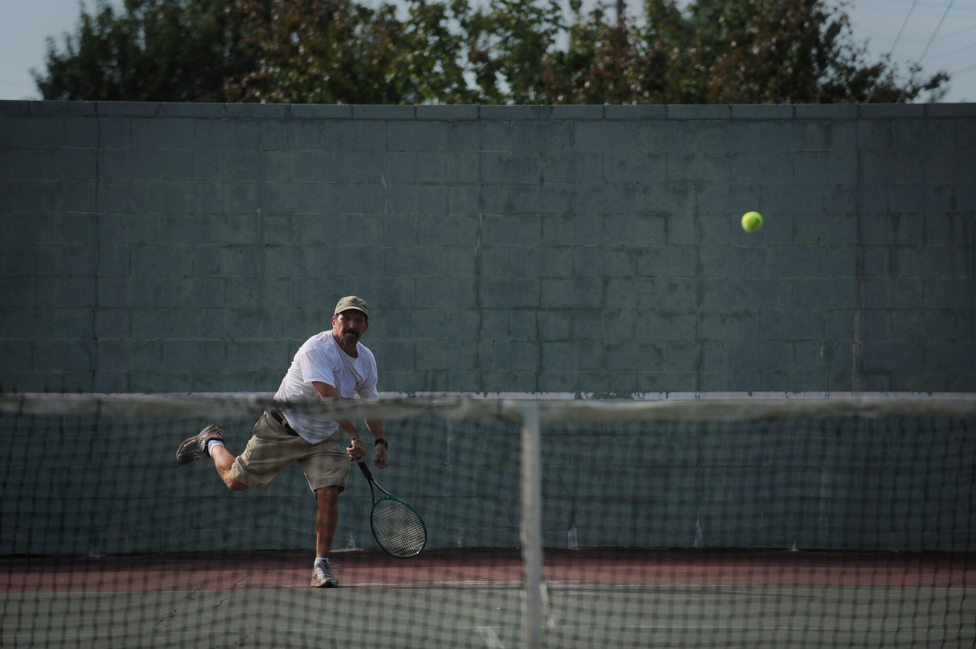 MOODY AIR FORCE BASE, Ga. -- Anthony Cuellar, 38th Rescue Squadron vehicle manager, runs to hit a tennis ball back to his opponent during a tennis match during the 23rd Wing Super Sports Day here Oct. 23. Throughout the day, units competed in numerous sporting events including tennis, softball, basketball and tug-of-war. (U.S. Air Force photo by Senior Airman Gina Chiaverotti-Paige)