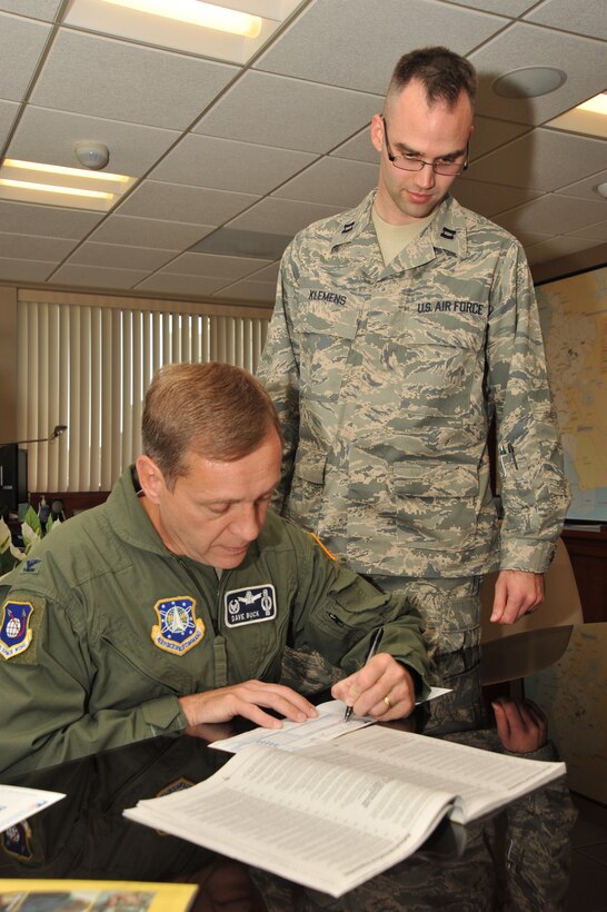 VANDENBERG AIR FORCE BASE, Calif. – Col. David Buck, the 30th Space Wing commander, kicks off the Combined Federal Campaign by making Vandenberg’s first donation as Capt. Adam Klemens, Vandenberg's CFC project officer, looks on Wednesday, Oct. 7, 2009. Vandenberg’s 2009 CFC, which is an annual fundraising event, is scheduled to run from Oct. 26 through Nov. 20. (U.S. Air Force photo/Senior Airman Stephanie Longoria)