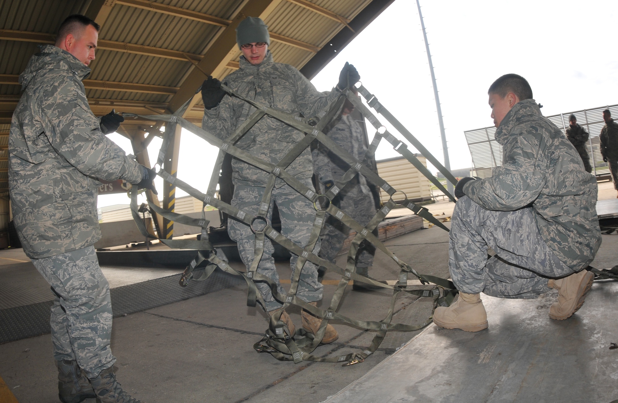 SPANGDAHLEM AIR BASE, Germany -- Staff Sgt. Paul Neyman and Airman Zachary Nuvy, both from the 606th Air Control Squadron, install top net to a cargo pallet during cargo pallet buildup training Oct. 21. The purpose of the class is to give Airmen the skills needed for cargo movement. (U.S. Air Force photo/Airman 1st Class Nick Wilson)