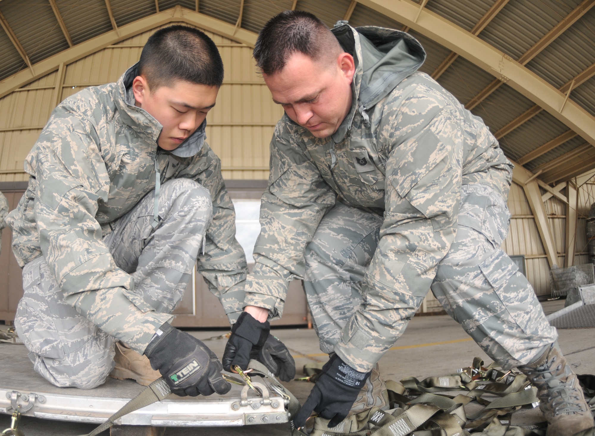 SPANGDAHLEM AIR BASE, Germany -- Airman 1st Class Richard Lee and Tech. Sgt. Eric Ramon, both from the 52nd Equipment Maintenance Squadron, install top net to a cargo pallet during cargo pallet buildup training Oct. 21. The purpose of the class was to give Airmen the skills needed for cargo movement. (U.S. Air Force photo/Airman 1st Class Nick Wilson)