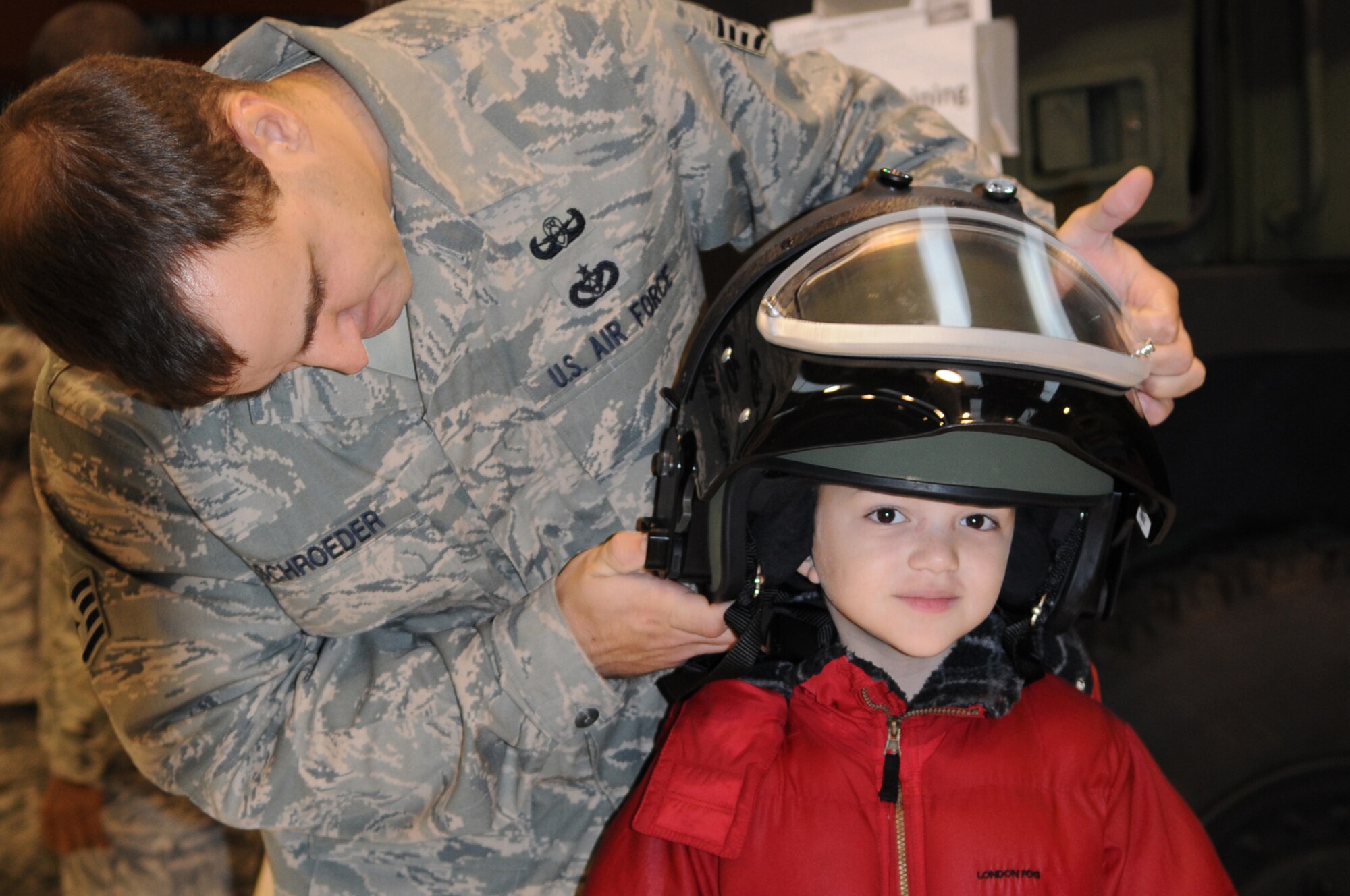 Staff Sgt. Jeffery Schroeder, 31th Civil Engineer Squadron, places an explosive ordinance bomb suit helmet on 8-year-old Devin Valenca during the Aviano Kids Deployment Day Oct. 22, 200 at Aviano Air Base, Italy. Elementary school students were briefed on a variety of subjects to include medical training, tactical survival skills and drill movements to better understand what their military parents may experience before, during or after a deployment. 
(U.S. Air Force photo/Senior Airman Nadine Barclay)