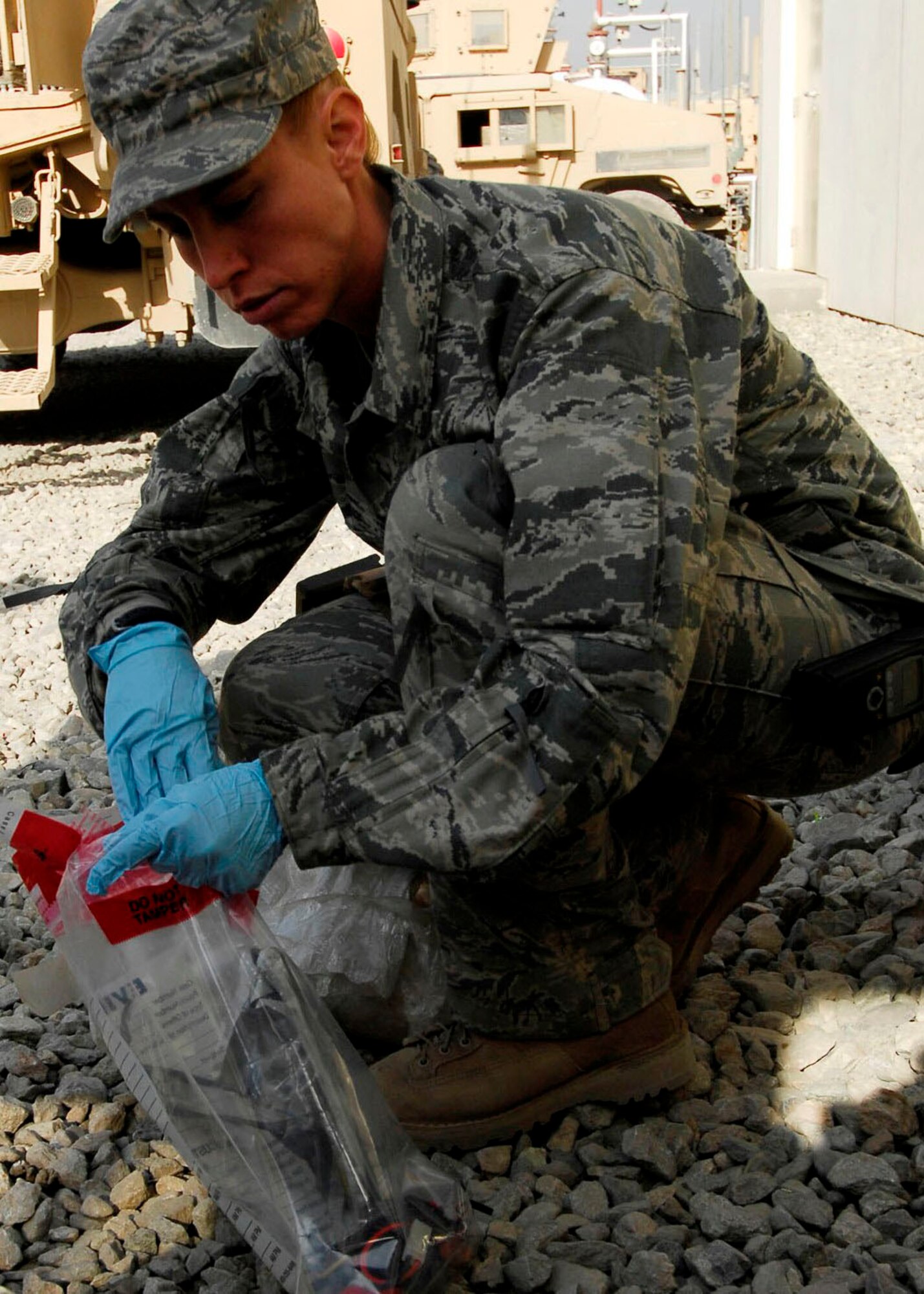 BAGRAM AIRFIELD, Afghanistan -- Staff Sgt. Elizabeth Spradley, an explosives ordnance disposal technician, collects evidence from a mock Improvised Explosive Device during training Oct. 26, 2009.  EOD uses robots during missions to disarm IEDs and look for additional IEDs.  The robots are used by Explosive Ordnance Disposal teams to ensure Coalition maximum safety is taken when dealing with IEDs.  The EOD Airmen are Joint Expeditionary Task Airmen from the 755th Air Expeditionary Group, 755th EOD Alpha Flight, attached to the 741st EOD Battalion.  Sergeant Spradley, an Albuquerque, N.M. native, is deployed from Spangdahlem Air Base, Germany.  (U.S. Air Force photo/Senior Airman Felicia Juenke)