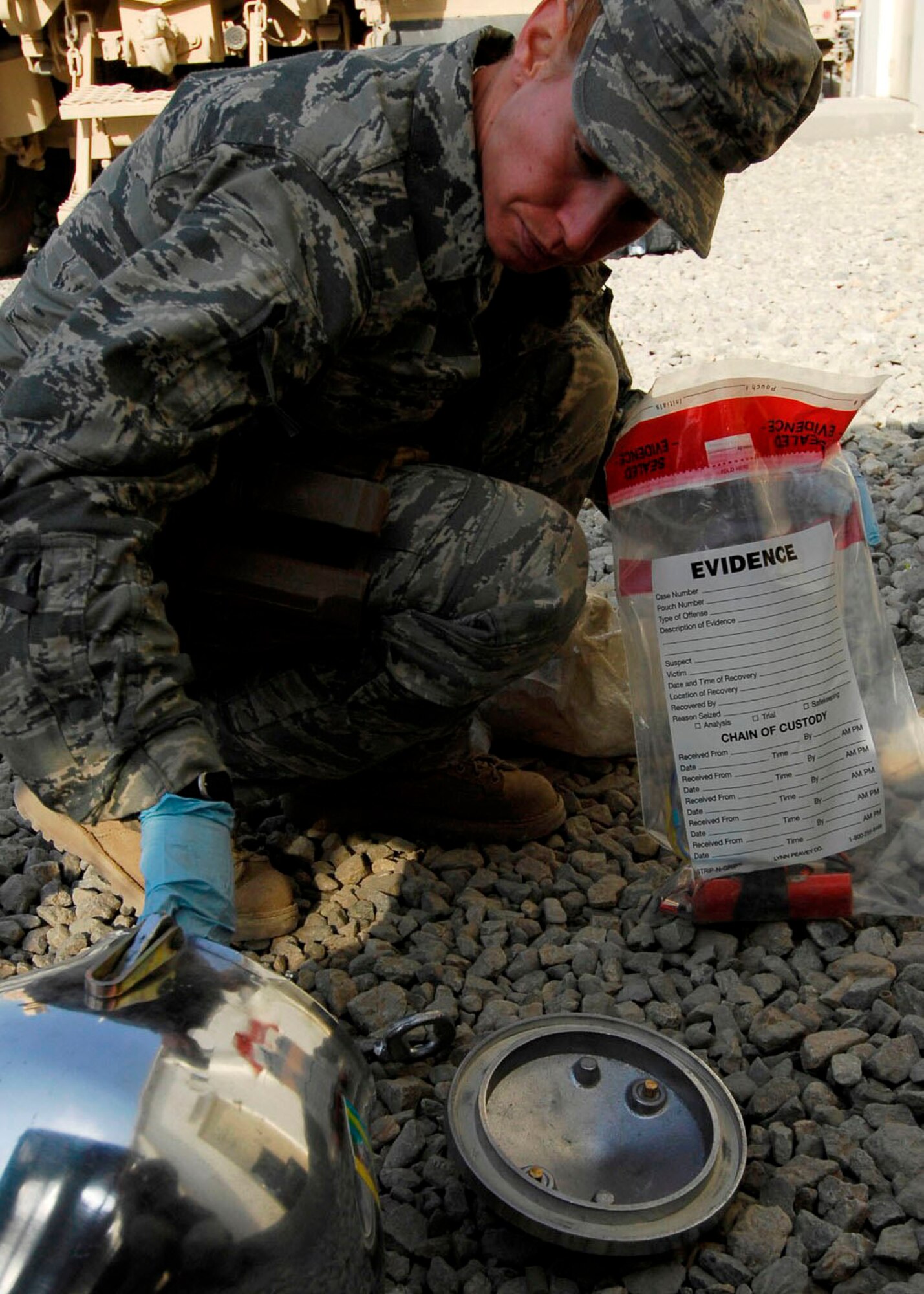BAGRAM AIRFIELD, Afghanistan -- Staff Sgt. Elizabeth Spradley, an explosives ordnance disposal technician, collects evidence from a mock Improvised Explosive Device during training Oct. 26, 2009.  EOD uses robots during missions to disarm IEDs and look for additional IEDs.  The robots are used by Explosive Ordnance Disposal teams to ensure Coalition safety is taken when dealing with IEDs.  The EOD Airmen are Joint Expeditionary Tasked Airmen from the 755th Air Expeditionary Group, 755th EOD Alpha Flight, attached to the 741st EOD Battalion.  Sergeant Spradley, an Albuquerque, N.M. native, is deployed from Spangdahlem Air Base, Germany.  (U.S. Air Force photo/Senior Airman Felicia Juenke)