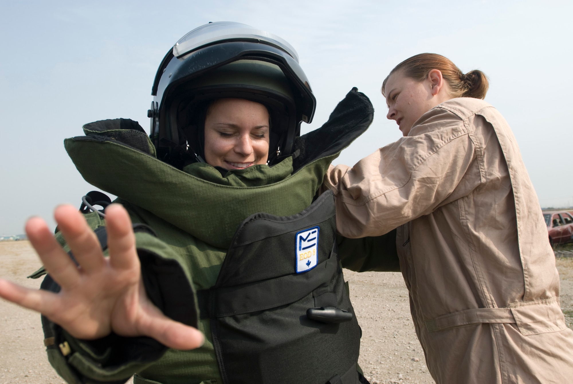 KUNSAN AIR BASE, Republic of Korea -- Senior Airman Jessica Roland, 8th Civil Engineer Squadron, helps 1st Lt. Elizabeth Combs, 8th Fighter Wing, put on an explosive ordnance disposal suit Oct. 22. Lieutenant Combs, an aerospace physiologist, went out with EOD to experience daily stressors that EOD goes through. (U.S. Air Force photo/Senior Airman Jonathan Steffen)