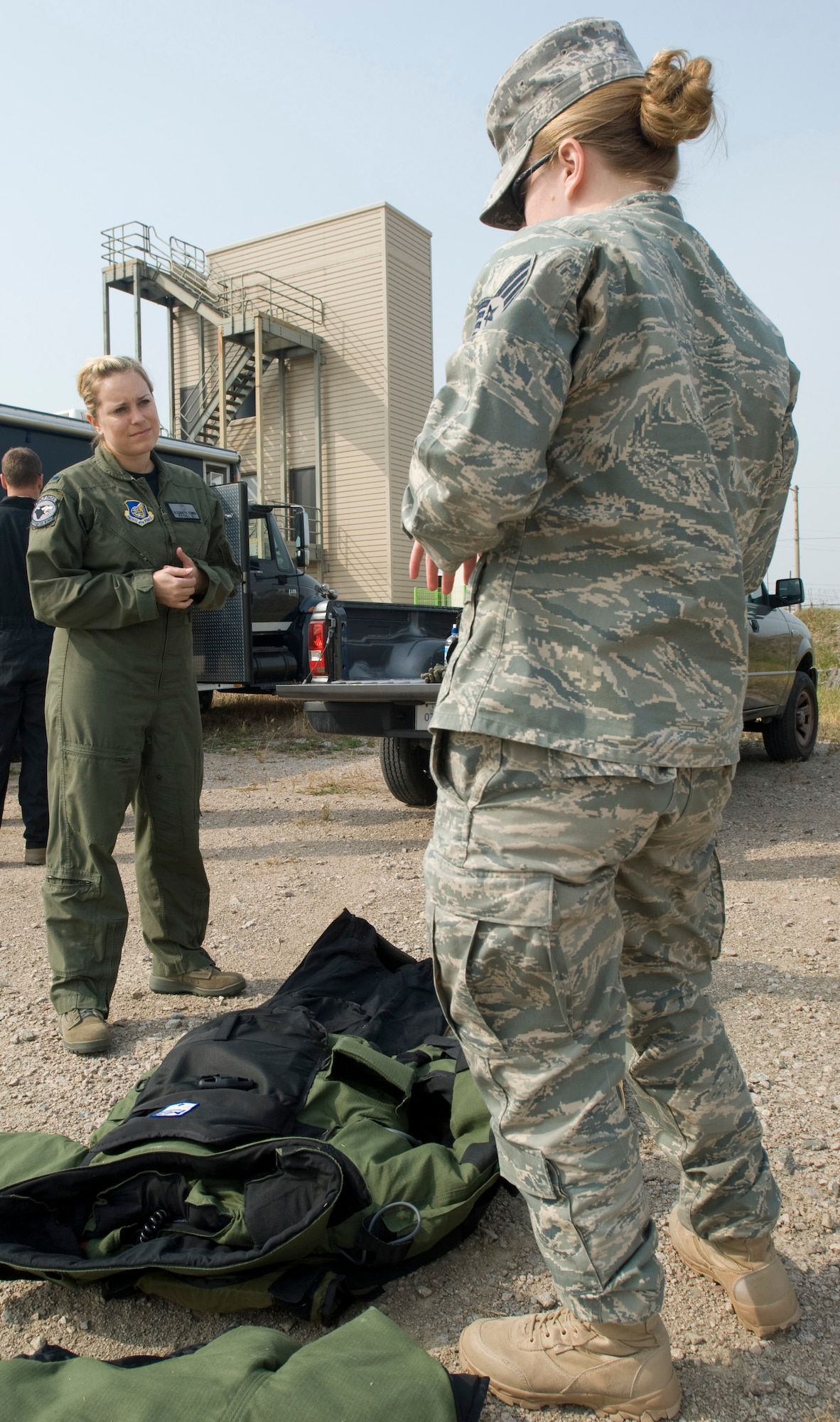 KUNSAN AIR BASE, Republic of Korea -- 1st Lt. Elizabeth Combs, 8th Fighter Wing,  listens to Staff Sgt. Jessica Lafo, 8th Civil Engineer Squadron, about what makes up an explosive ordnance disposal suit Oct. 22. Lieutenant Combs is an aerospace physiologist. She went out with EOD to experience the daily stressors that the EOD equipment puts on the body. (U.S. Air Force photo/Senior Airman Jonathan Steffen)