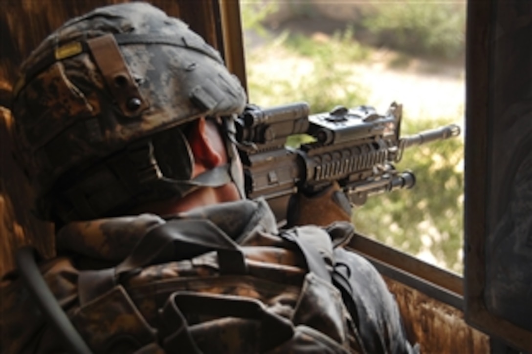 A U.S. Army soldier provides security for Wasit Provincial Reconstruction Team members during a visit to the Professional Teachers Training Center in Kut, Iraq, Oct. 21, 2009. The team's members were discussing an upcoming seminar on women. The soldier is assigned to the 1st Battalion, 77th Field Artillery Regiment.