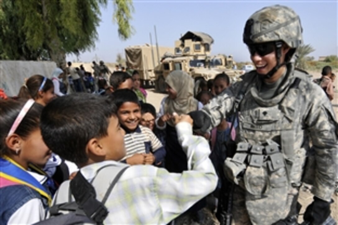 U.S. and Iraqi soldiers conduct humanitarian aid drops of school supplies to the Al Fetoah School near Baghdad, Oct. 21. The soldiers distributed more than 100 book bags filed with pencils, notebooks and other school supplies to underprivileged students. The U.S. soldiers are assigned to the 1st Cavalry Division's 1st Battalion, 120th Armored Reconnaissance Squadron, 30th Heavy Brigade Combat Team.