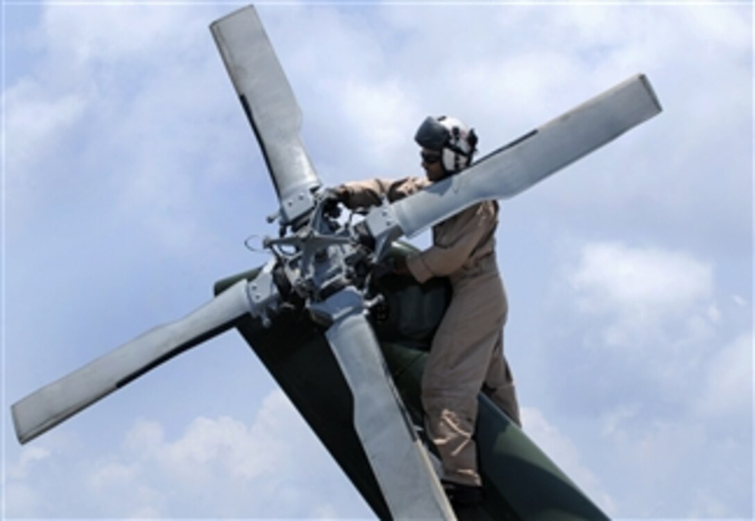 U.S. Navy Lt. Cmdr. Loren Romeus, assigned to Helicopter Anti-Submarine Squadron Light 51, inspects the tail of an SH-60F Seahawk helicopter before flight quarters aboard the U.S. 7th Fleet command ship USS Blue Ridge (LCC 19) in the Pacific Ocean on Oct. 22, 2009.  The Blue Ridge is the flagship for Commander, U.S. 7th Fleet.  