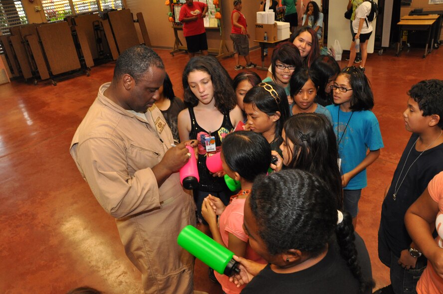 Tech. Sgt. Terry Grace, U.S. Air Force Band of the Pacific-Hawaii bass guitarist, signs autographs for the students of Kaleiopuu elementary School in Waipahu, Hawaii Oct 22  as part of Red Ribbon Week, a program aimed at reinforcing children's decisions to stay away from drugs and make positive decisions in life. (U.S. Air Force photo/Tech Sgt. Cohen A. Young)