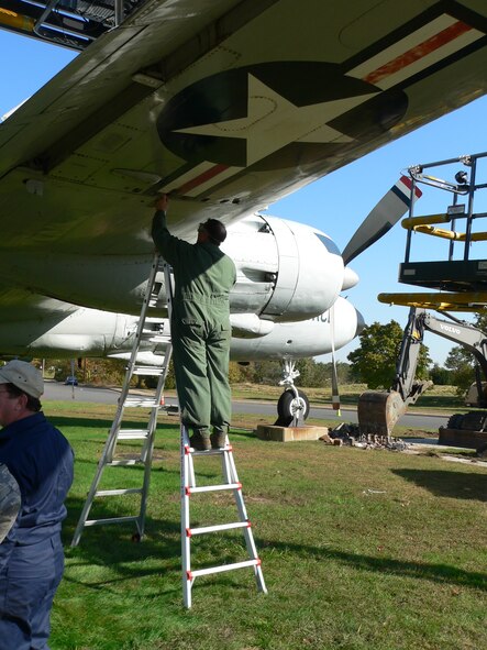 A member of the team restoring a historical C-118 Liftmaster at Joint Base McGuire-Dix-Lakehurst, N.J., begins to remove the aircraft's wings on Oct. 20, 2009. The aircraft was located in front of the 305th Air Mobility Wing passenger terminal. It has been guarding the passenger terminal for 27 years with little maintenance. (U.S. Air Force Photo/Steve Snyder) 
