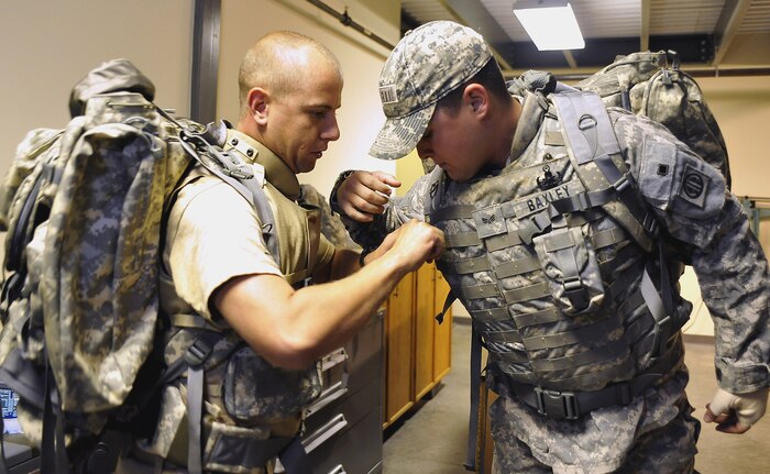 Staff Sgt. Brian Thorne,left, assists Senior Airman Johnathan Baxley with his ruck sack  prior to a  march with 437th Civil Engineer Squadron Explosive Ordnance Disposal Flight here Oct. 27. EOD has ruck marched for two and a half months, preparing for Afghanistan deployments. Airman Baxley is an EOD journeyman and Sergeant Thorne is the EOD apprentice, both are with the 437 CES.(U.S. Air Force photo/James Bowman)