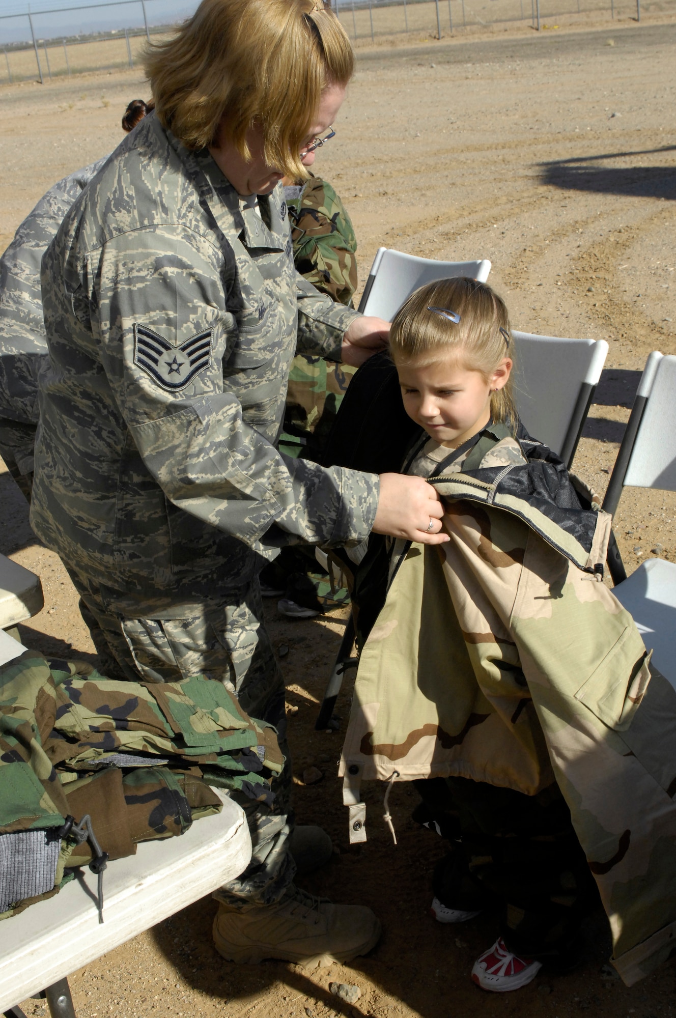 Ellie Welcott, 6, has Mission Oriented Protective Posture (MOPP) gear put on by Staff Sgt. Miranda Mal, 56th Civil Engineer Squadron emergency management, while "deployed" in support of the 2009 Operation Kids event, Oct. 24, 2009, Luke Air Force Base, Arizona. (U.S. Air Force Photo by Staff Sgt. Jason Colbert)