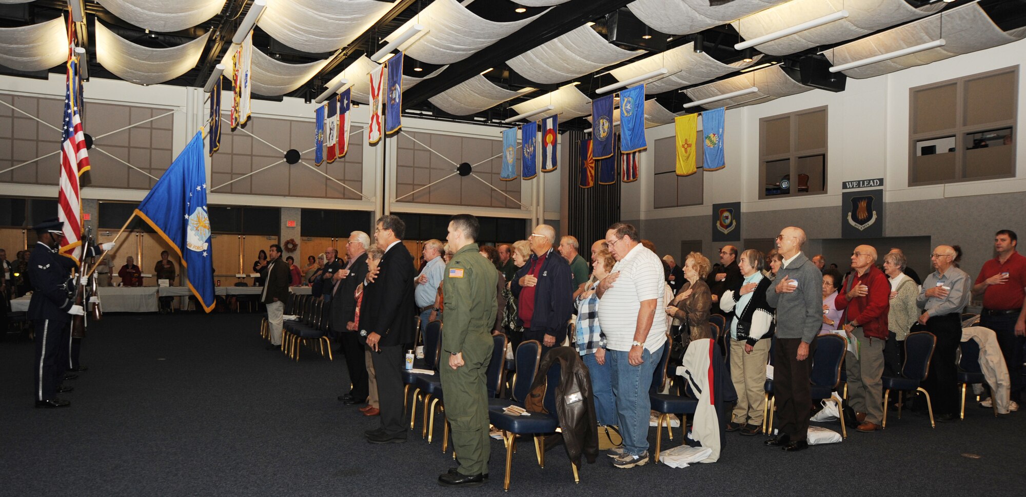 People pay respect to the American flag during the pledge of allegiance, Oct. 24, 2009, at Retiree Appreciation Day at McConnell Air Force Base, Kan. The day-long event included activities ranging from free medical screenings to a complimentary breakfast and wine tasting. (U.S. Air Force Photo/Airman 1st Class Ruiz)