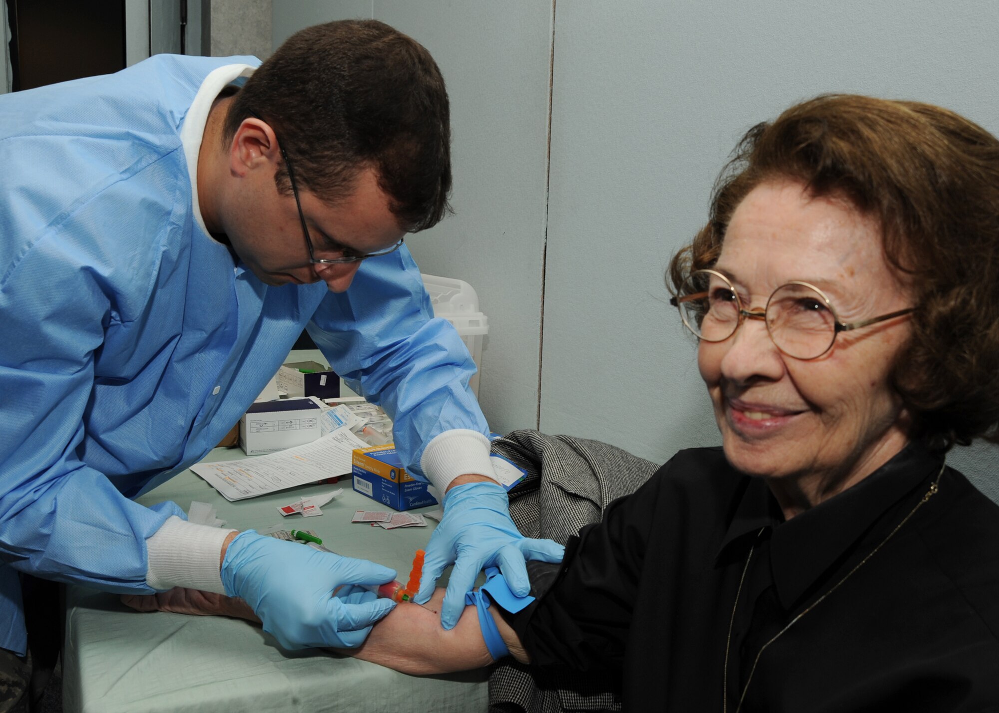 Staff Sgt. Pedro Rivera, an Air National Guardsman from the 184th Medical Group, draws blood from Colleen Wooley, wife of retired Army Col. John Wooley, Oct. 24, 2009, during a free medical screening at Retiree Appreciation Day at McConnell Air Force Base, Kan. Base medical personnel took blood samples from interested Retiree Appreciation Day participants and will screen the samples for diabetes, abnormal cholesterol levels and, for men, prostate cancer. (U.S. Air Force Photo/Airman 1st Class Ruiz)