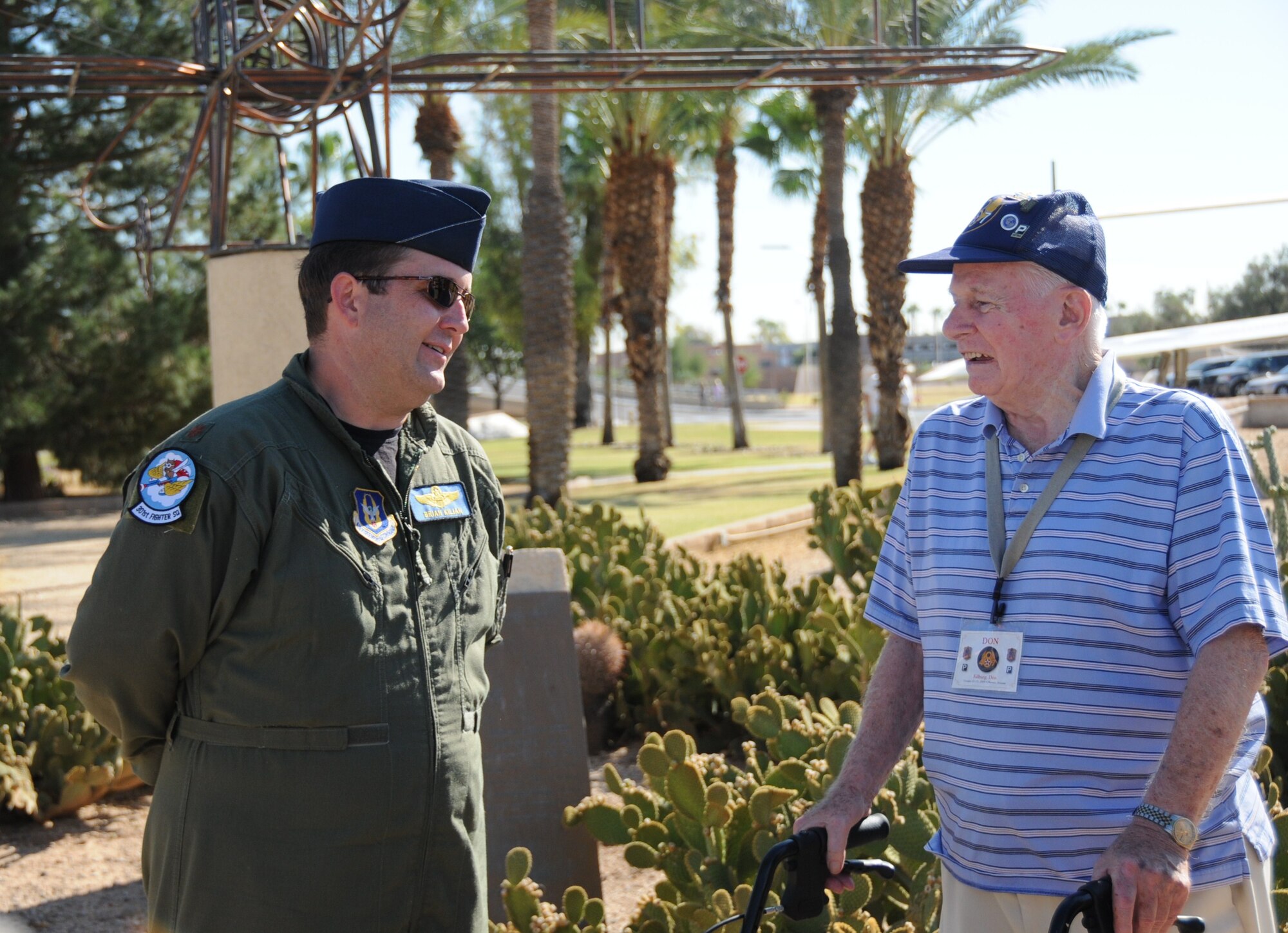 Maj. Brian Kilian, an instructor pilot with the 301st Fighter Squadron, talks with Don Kilburg, a member of the 487th Bomb Group during a tour Oct. 23 at Luke Air Force Base, Ariz. The 486th and 487th Bomb Groups conducted their annual reunion in Phoenix and visited the base as one of their events. (U.S. Air Force photo/Tech. Sgt. Susan Stout)