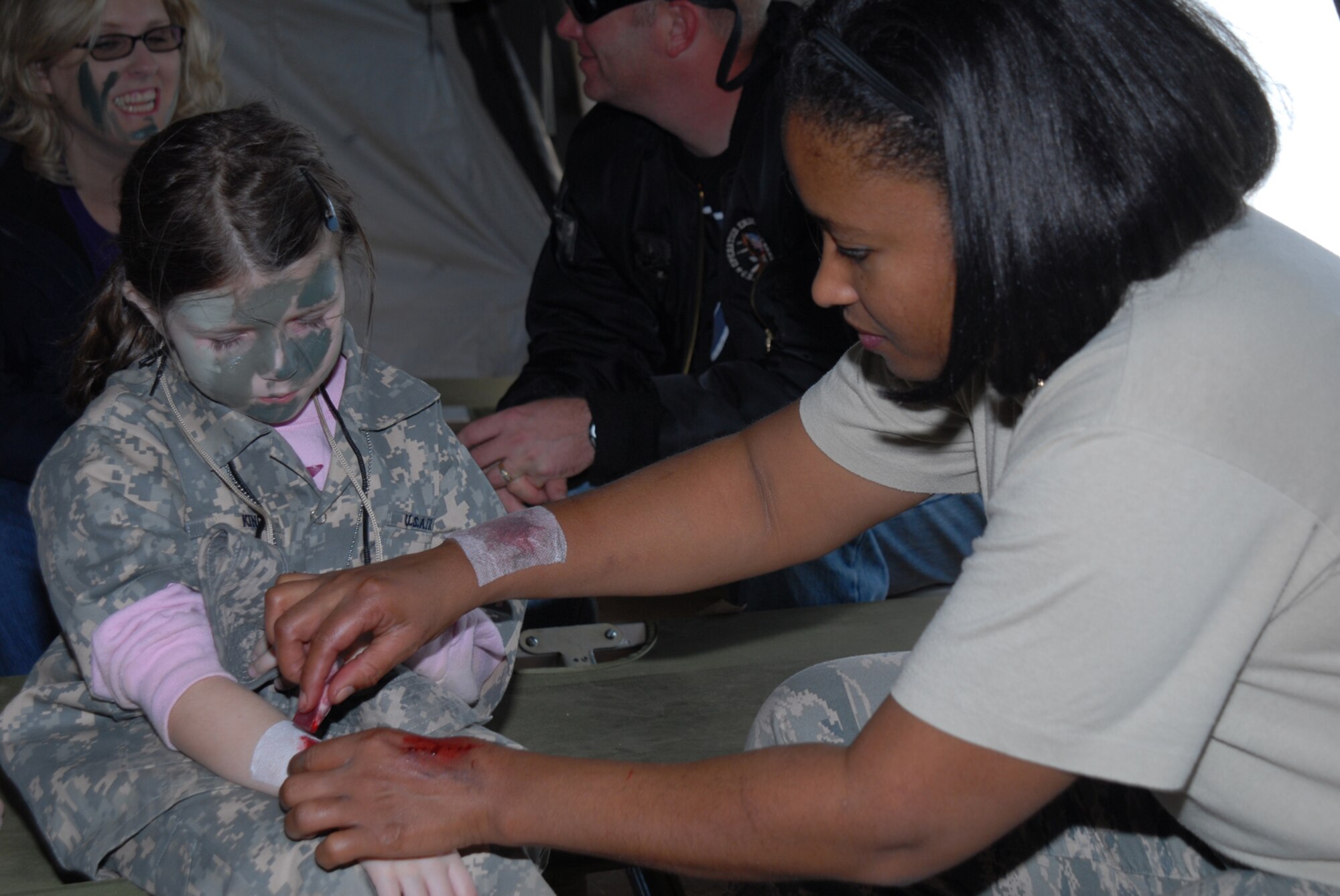 GOODFELLOW AIR FORCE BASE, Texas -- Master Sgt. Kaleah Hodges, 17th Medical Group, applies fake blood to Evelynn King, daughter of Staff Sgt. Sarah Rucker, 316th Training Squadron instructor, during Operation Kids, Oct. 24, 2009. Operation Kids is a group of activities designed to increase dependents' understanding of the deployment process. (U.S. Air Force photo/Staff Sgt. Laura R. McFarlane)