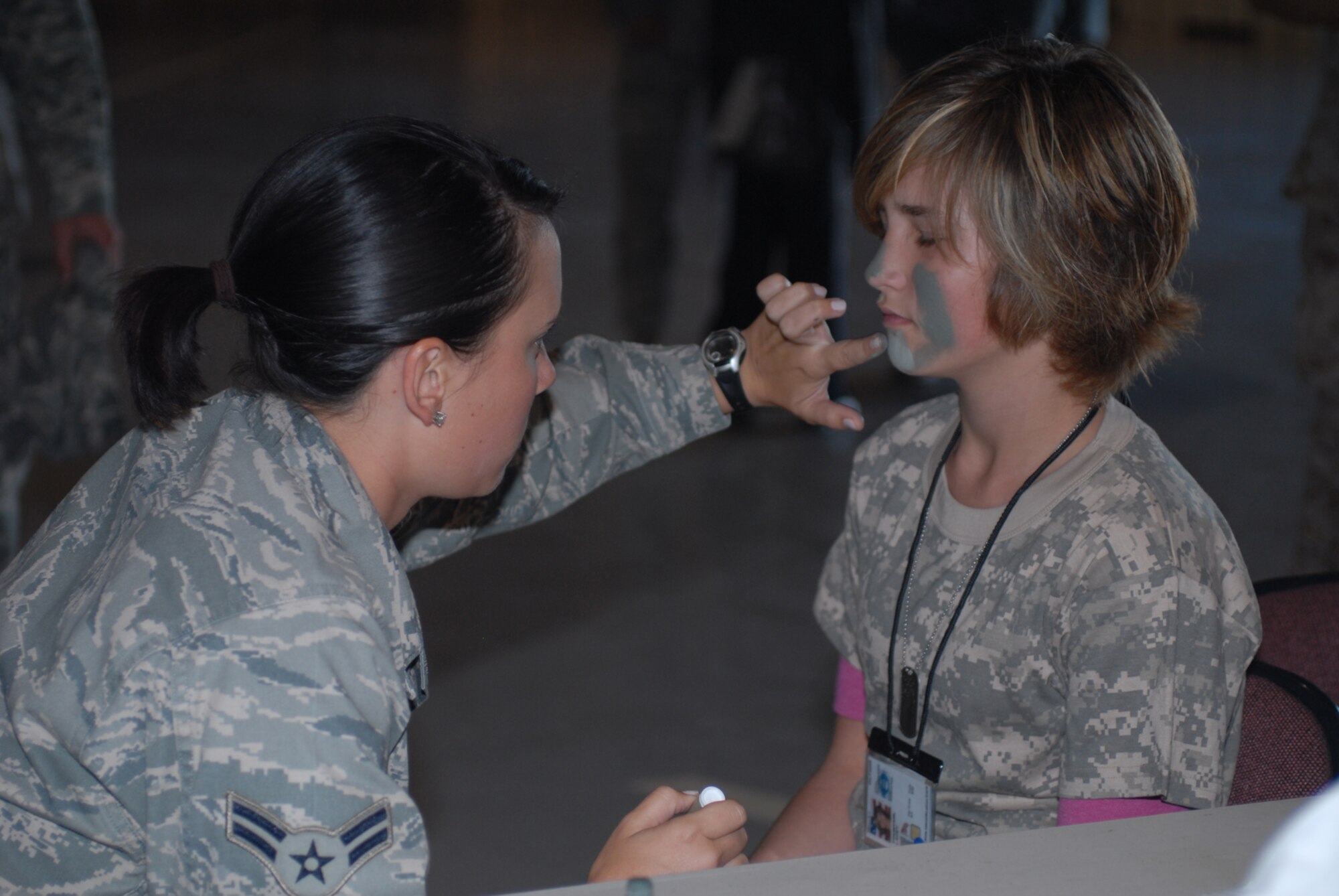 GOODFELLOW AIR FORCE BASE, Texas -- Lacey Fountain, daughter of Staff Sgt. James Fountain, 17th Training Wing safety, has camouflage applied by Airman 1st Class Kira Spalding, 316th Training Squadron student, during Operation Kids, Oct. 24, 2009. Operation Kids is a group of activities designed to increase dependents' understanding of the deployment process. (U.S. Air Force photo/Staff Sgt. Laura R. McFarlane)