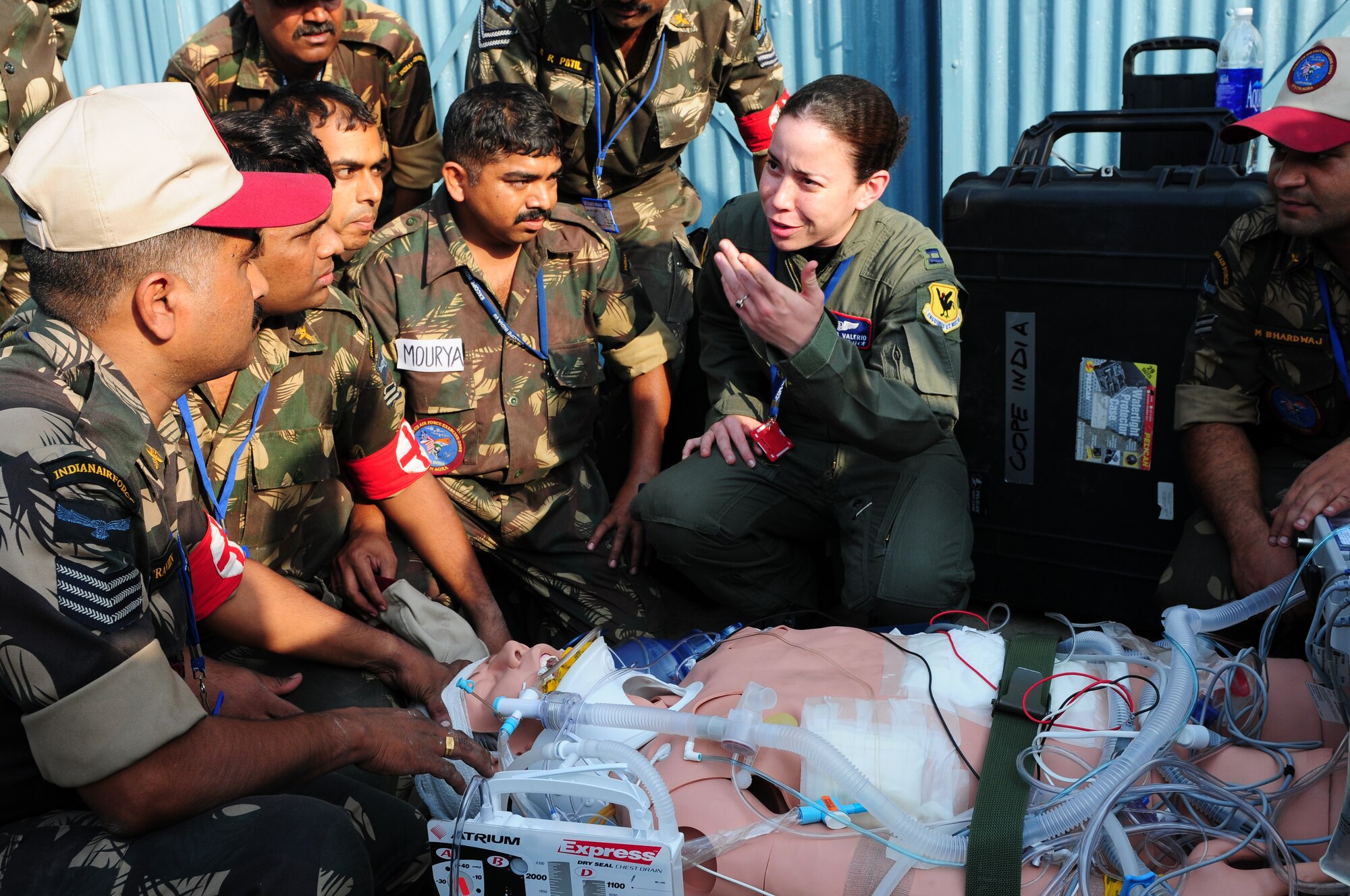 U.S. Air Force Capt. Veronica Valerio, from the 18th Wing, Kadena Air Base, Japan, explains to several Indian air force medics emergency response techniques to a mannequin patient during a U.S. Air Force combat casualty demonstration at Cope India at Air Force Station Agra, India. Cope India is a United States and India airlift exercise that provides training for humanitarian assistance and disaster relief operations. (U.S. Air Force photo/Capt. Genieve David)