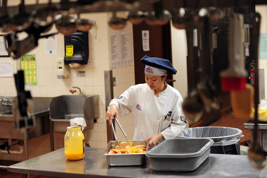 OFFUTT AIR FORCE BASE, Neb. - Senior Airman Oanh Moraine, a food service specialist with the 55th Force Support Squadron, marinates a batch of chicken in preparation the dinner service at the Ronald L. King Dining Facility here Oct. 22.  The King Dining Facility serves more than 17,000 meals a month providing food for Offutt's warriors. Air Combat Command's Hennessy Inspection Team visits Offutt Nov. 1 - 4 to evaluate the King Dining Facility and the Campsisi Dining Facility as they compete for the prestigious Hennessy Award, an honor that recognizes the best Dining Facility Program in the Air Force. U.S. Air Force Photo by Josh Plueger