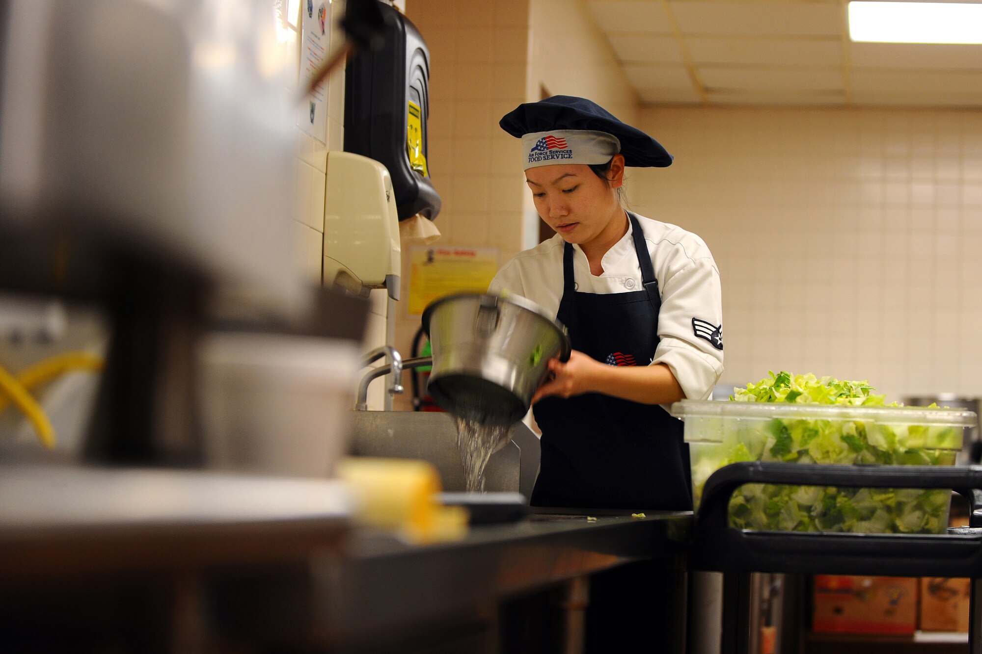 OFFUTT AIR FORCE BASE, Neb. - Senior Airman Oanh Moraine, a food service specialist with the 55th Force Support Squadron, washes lettuce in preparation for lunch at the Ronald L. King Dining Facility here Oct. 22. The King Dining Facility serves more than 17,000 meals a month providing food for Offutt's warriors. Air Combat Command's Hennessy Inspection Team visits Offutt Nov. 1 - 4 to evaluate the King Dining Facility and the Campsisi Dining Facility as they compete for the prestigious Hennessy Award, an honor that recognizes the best Dining Facility Program in the Air Force. U.S. Air Force Photo by Josh Plueger


