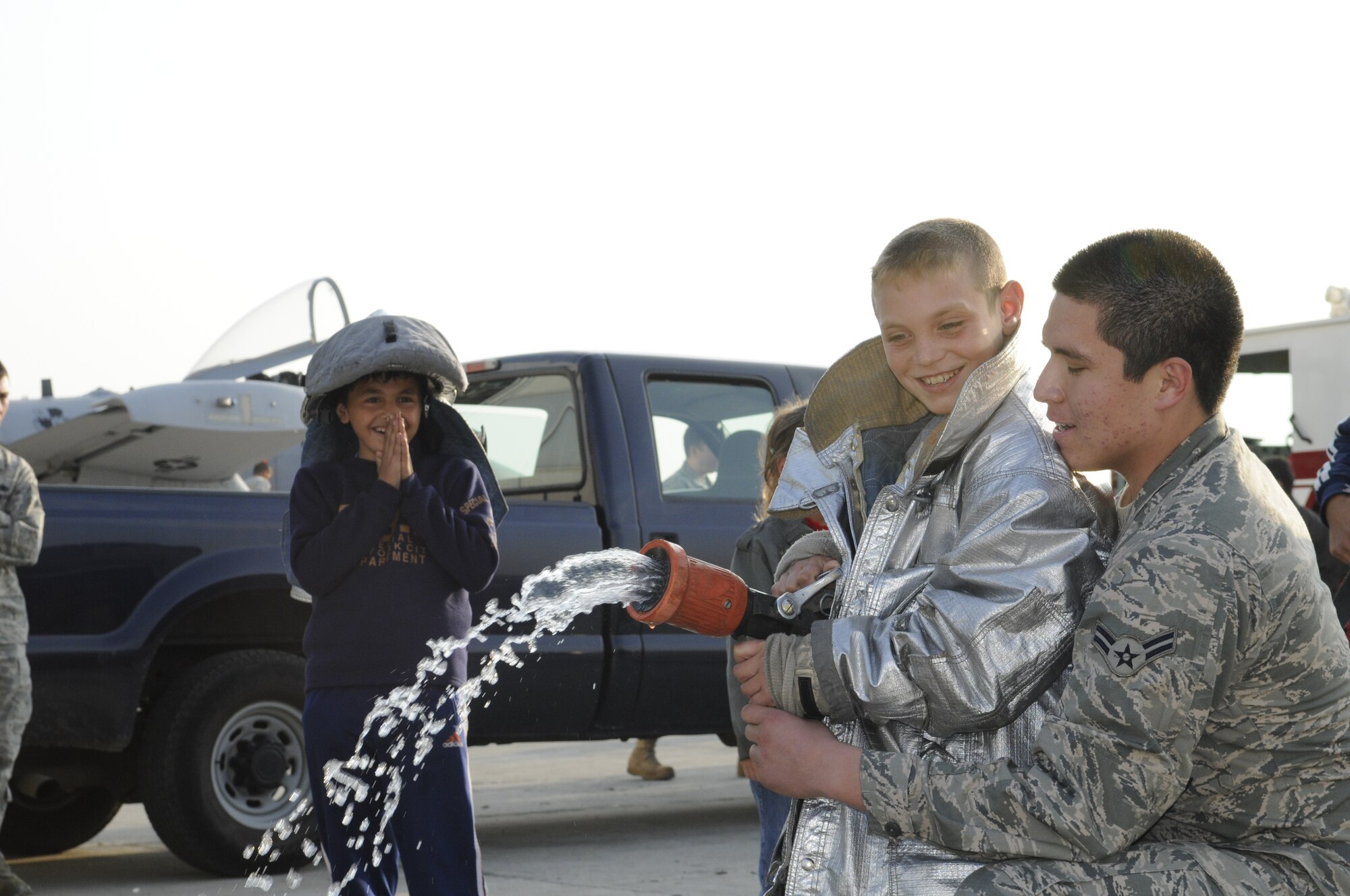 CAMPIA TURZII, Romania – Airman 1st Class Anthony Alvarez, 52nd Civil Engineer Squadron, helps a Romanian boy spray a fire hose during his visit to the 71st Air Base Wing Oct. 26. Members of Spangdalem Air Base deployed in support of Operation Dacian Thunder 2009 explained the parts of an A-10 Thunderbolt II static display and a fire truck during to children from the town of Turda, Romania, during their visit. The deployed units also donated money and time to help renovate a community center dedicated to helping local children with their academic studies. (U.S. Air Force photo/Senior Airman Benjamin Wilson)