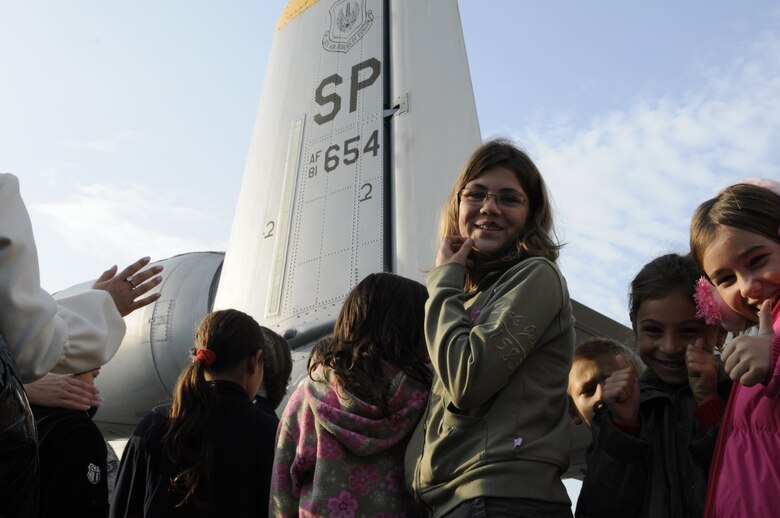 CAMPIA TURZII, Romania – Children from the town of Turda, Romania, smile in front of a static display of an A-10 Thunderbolt II while visiting the 71st Air Base Wing Oct. 26. Members of Spangdalem Air Base deployed in support of Operation Dacian Thunder 2009 explained the parts of the A-10 and let them operate the hose of a fire truck during their visit. The deployed units also donated money and time to help renovate a community center dedicated to helping local children with their academic studies. (U.S. Air Force photo/Senior Airman Benjamin Wilson)