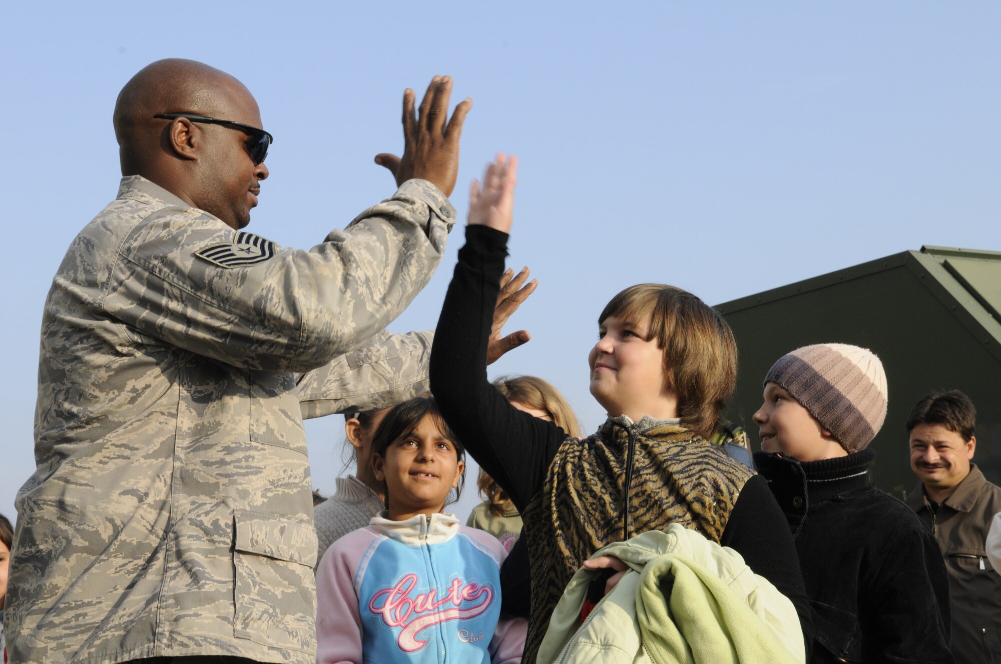 CAMPIA TURZII, Romania – Tech. Sgt. Dexter High, 81st Aircraft Maintenance Unit, high-fives Romanian school children during their visit to the 71st Air Base Wing Oct. 26. Members of Spangdalem Air Base deployed in support of Operation Dacian Thunder 2009 showed the children a static display of an A-10 Thunderbolt II and let them operate the hose of a fire truck during their visit. The deployed units also donated money and time to help renovate a community center dedicated to helping local children with their academic studies. (U.S. Air Force photo/Senior Airman Benjamin Wilson)