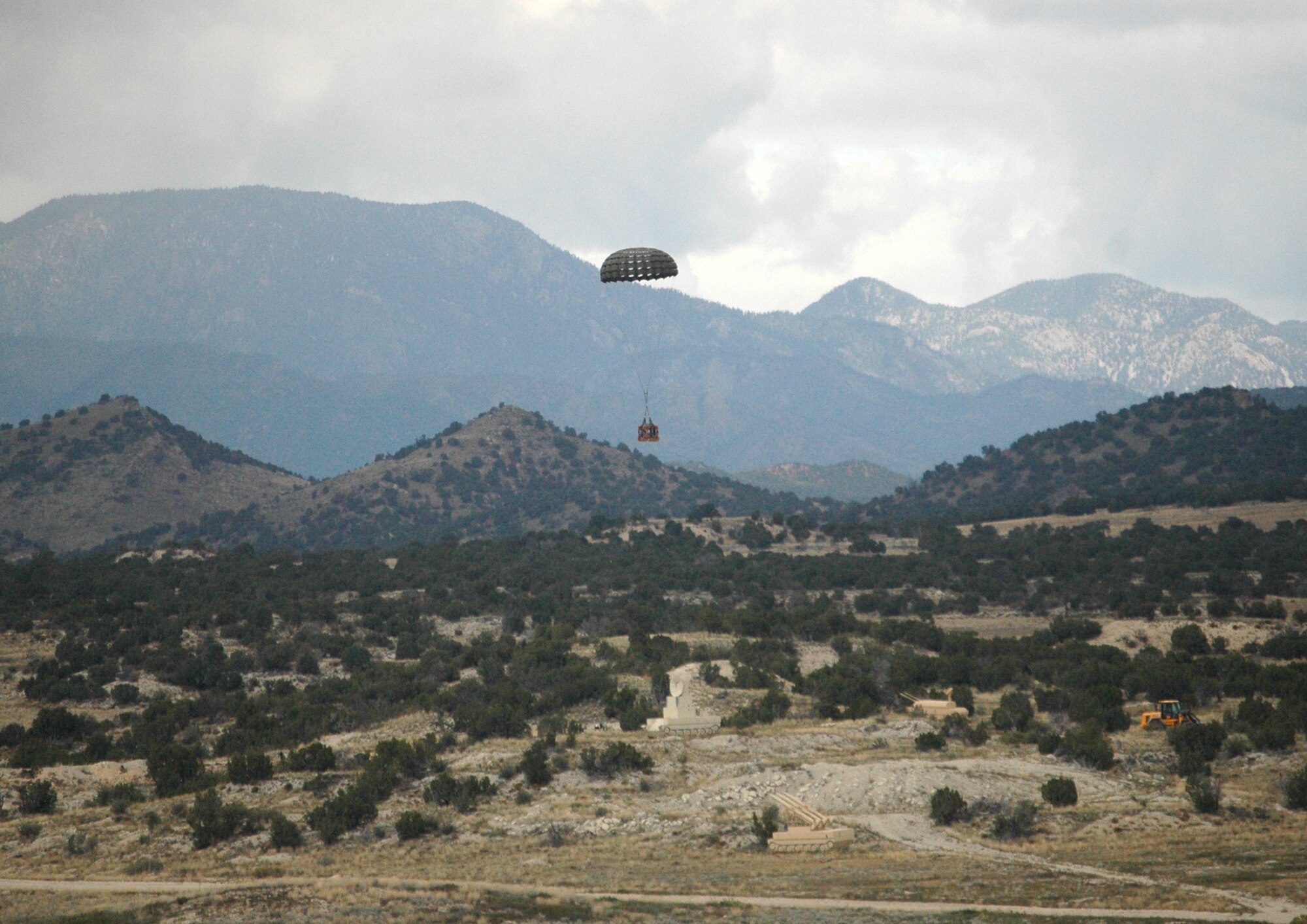 A simulated container delivery system falls to Earth Sept. 24 after an Air Force Reserve C-130 Hercules assigned to the 302nd Airlift Wing air dropped it over Fort Carson, Colo. The drop was in support of the U.S. Air Force Academy's Airdrop Enhanced Logistics Visibility System prototype system that demonstrated the ability of commanders in the field and at the headquarters level to simultaneously identify the location and contents of a CDS within minutes of the cargo leaving the aircraft. The AELVIS program aims to provide war fighters in locations like Iraq and Afghanistan with exact details on crucial cargo drops for resupply. (U.S. Air Force photo/Capt. Jody L. Ritchie)